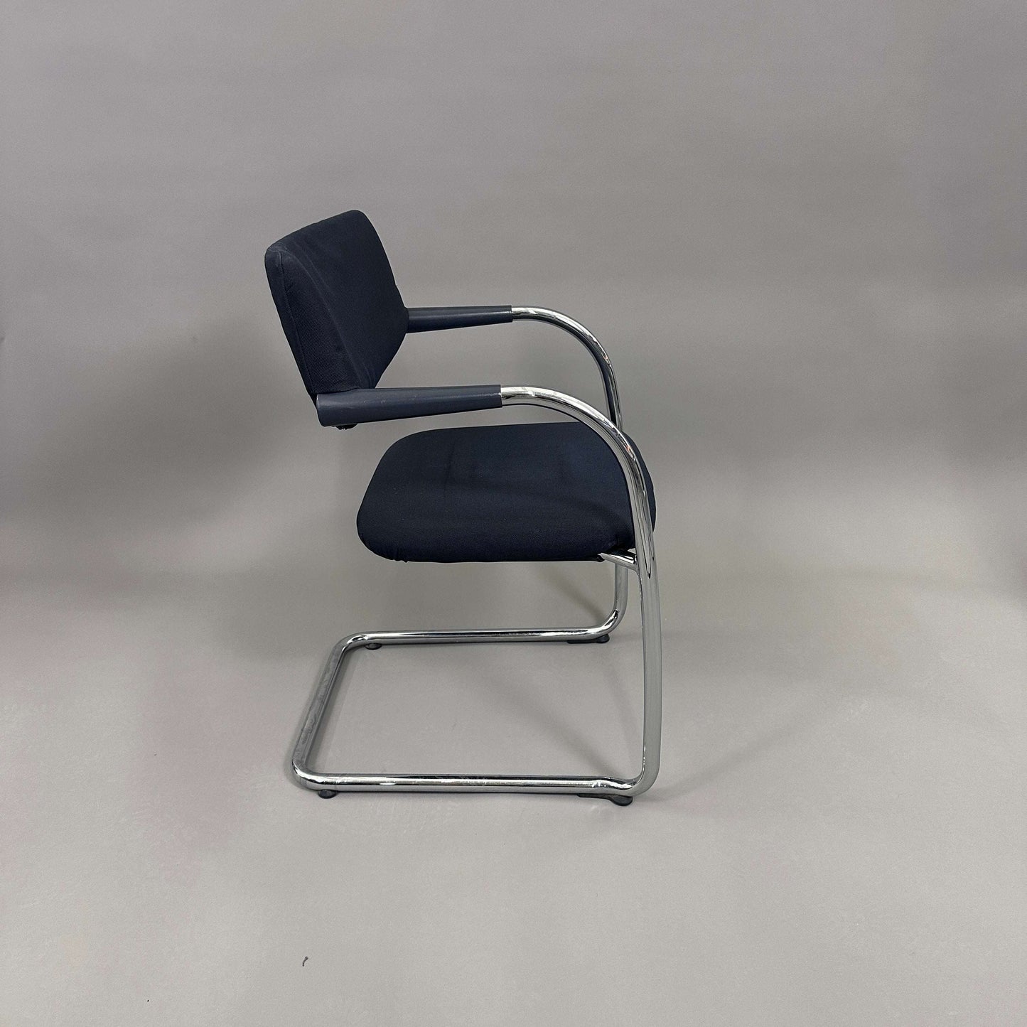 Vitra Visavis Softback chair with black fabric upholstery, chrome frame, padded backrest, and plastic armrests
