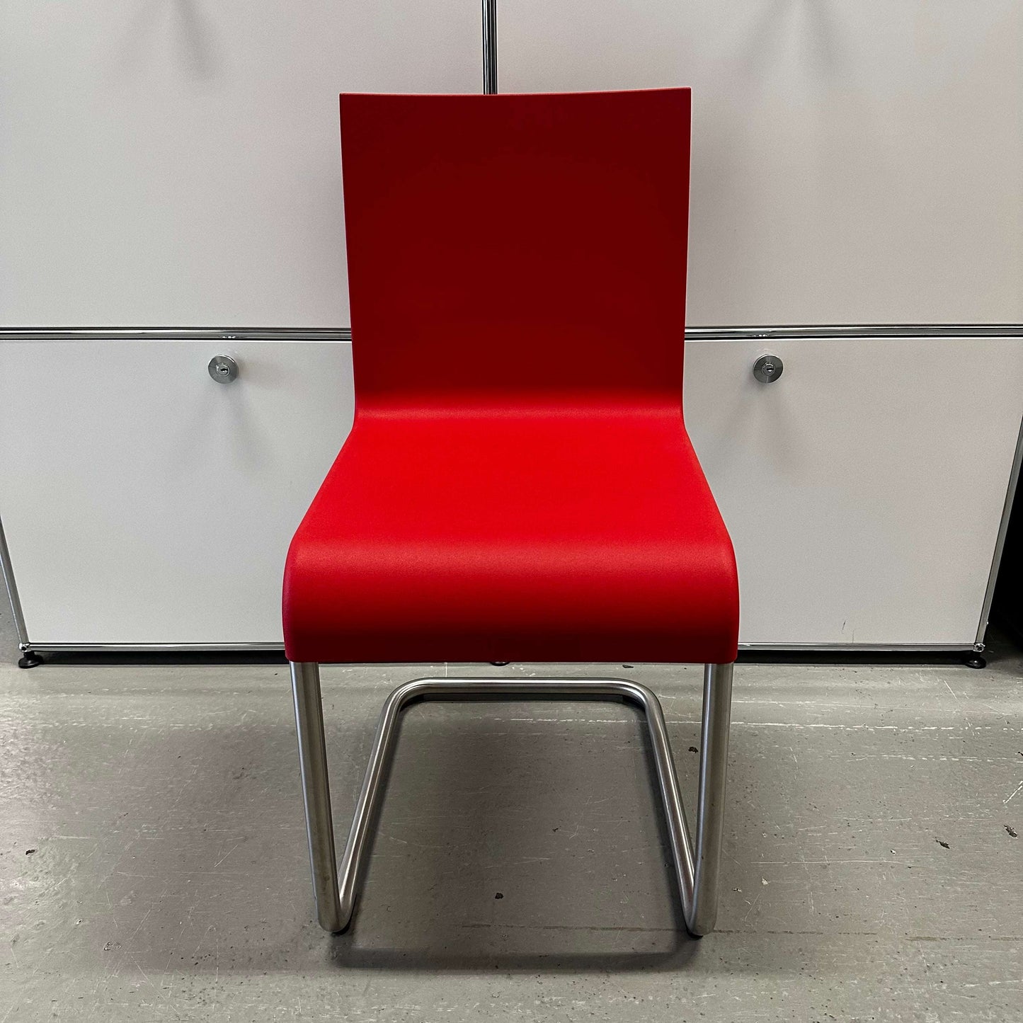 Vitra .05 Maarten van Severen chair with stainless steel frame and signal red polyurethane seat designed for indoor and outdoor use