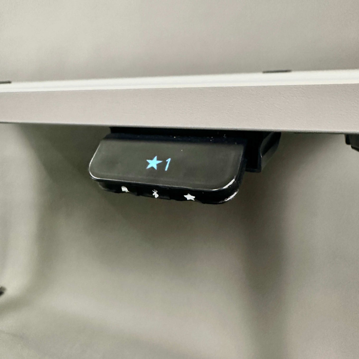 Close-up of WINI Flow Schreibtisch electric height adjustment control panel with star button and numeric display under 160x80cm desk surface
