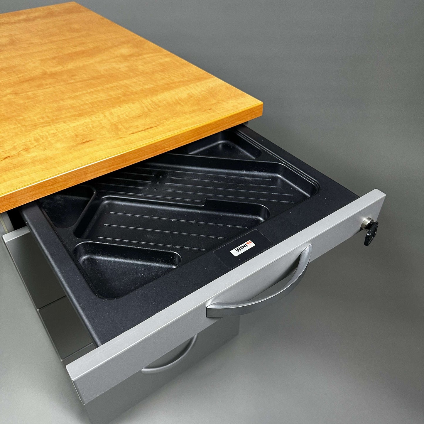 WINI Standcontainer mit fünf Schubladen in dunkelgrauem Korpus und heller Holzplatte, offene Schublade mit Einsatz für Ordnung