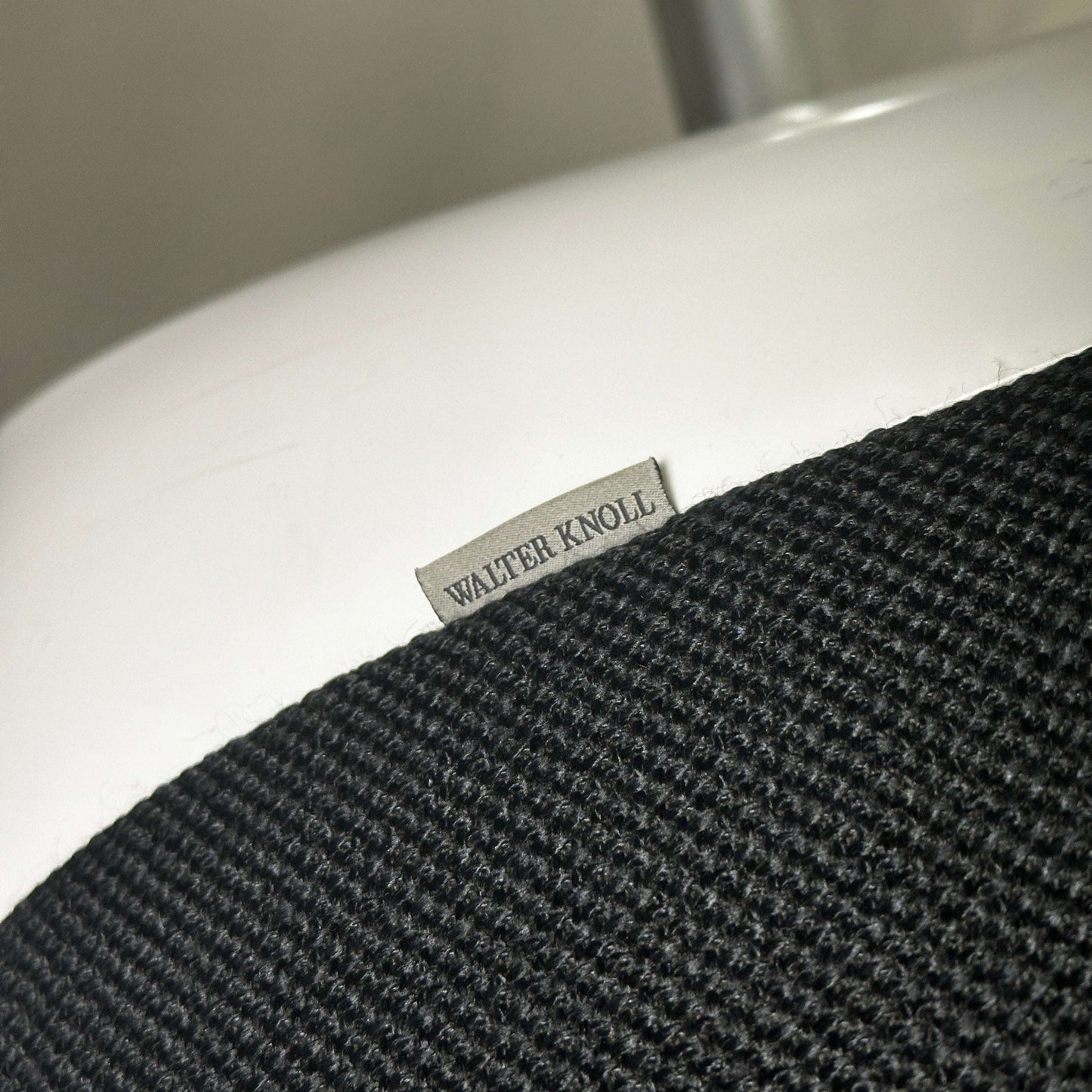 Nahaufnahme des Walter Knoll Turtle Lounge Chair mit schwarzem Stoffbezug und weißem Aluminium-Rundfußgestell