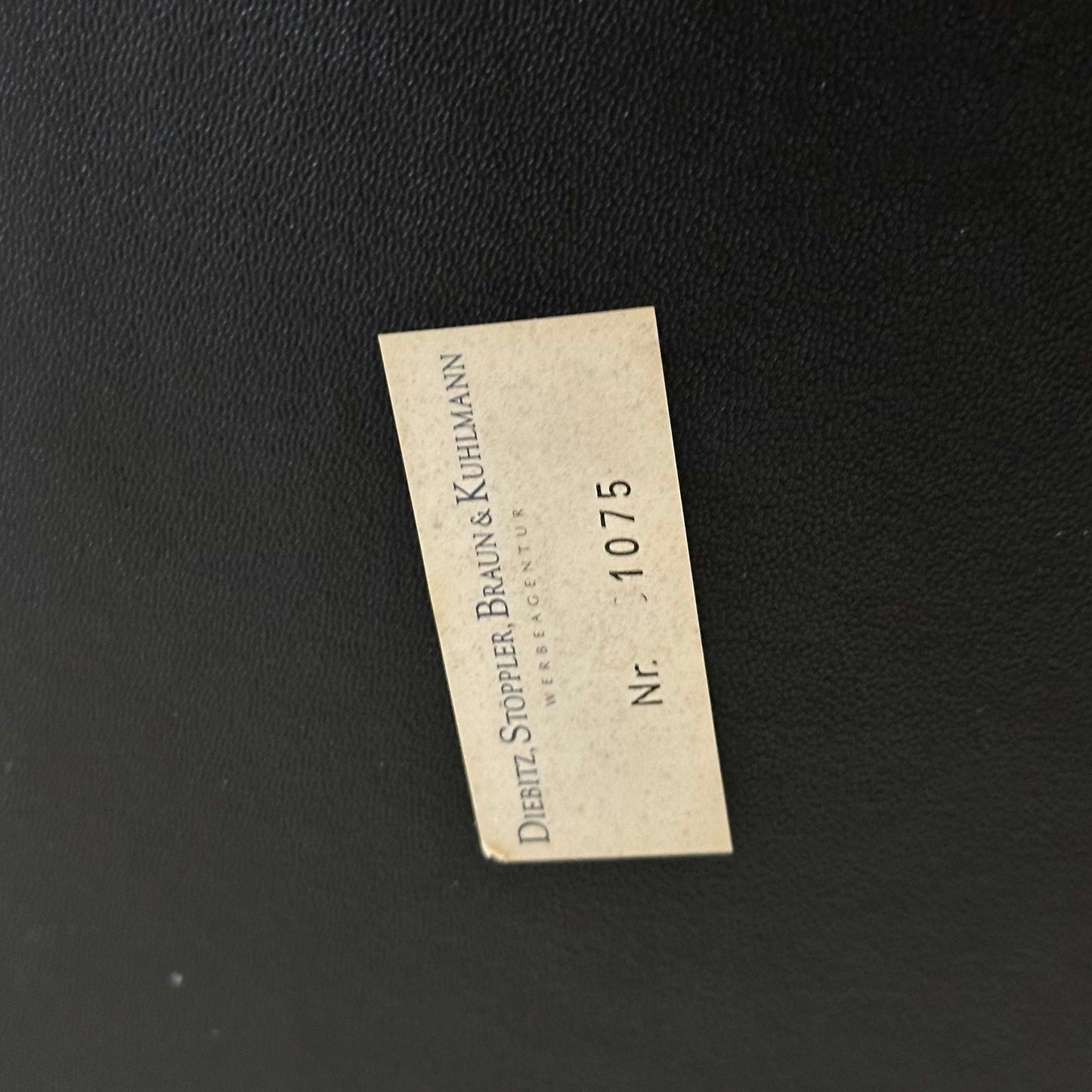 Close-up of the black leather upholstery with a Dietz Stoppler Braun & Kuhlmann label on the Wassily/Knoll Sessel replica chair.