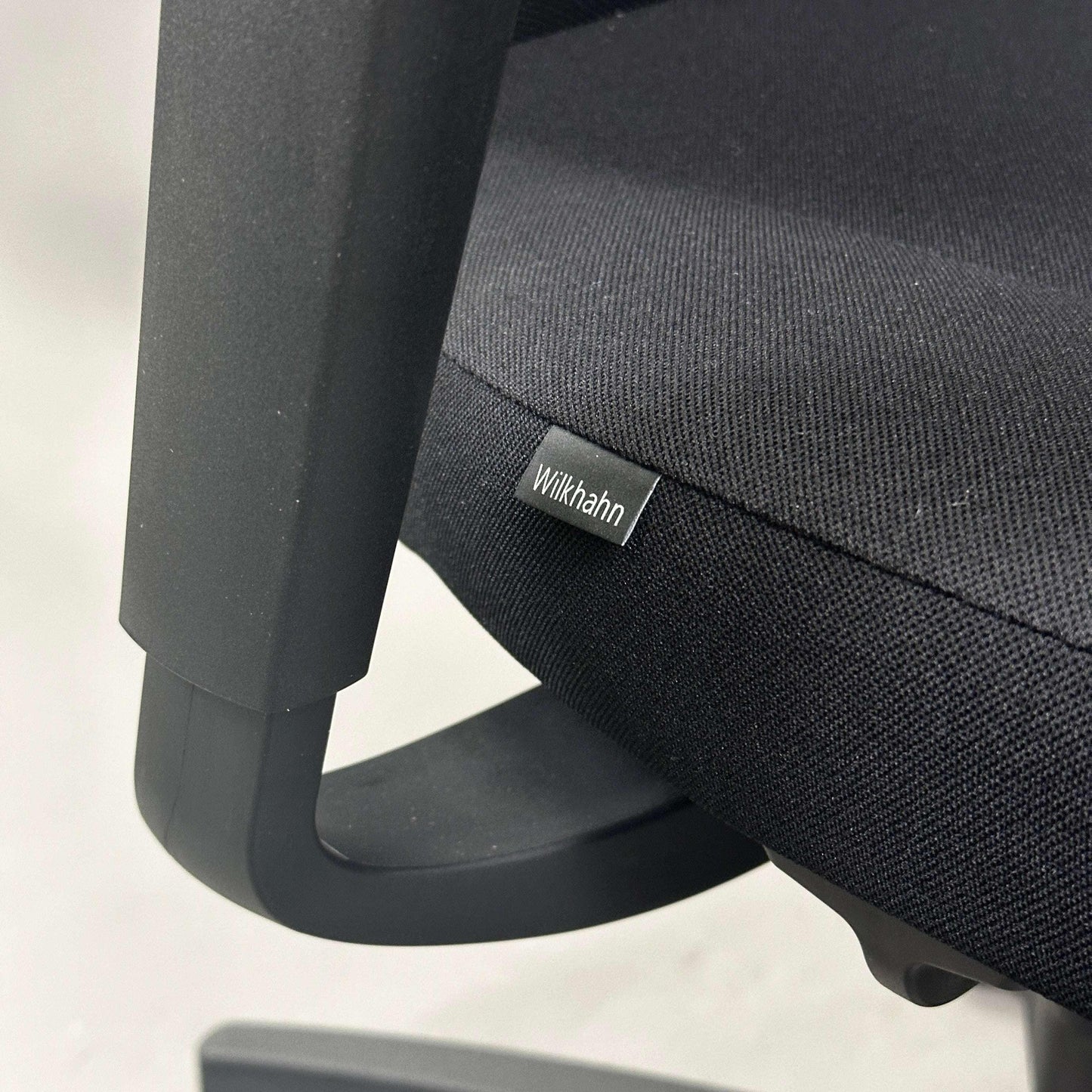 Close-up of Wilkhahn IN office chair with black fabric seat and adjustable armrest