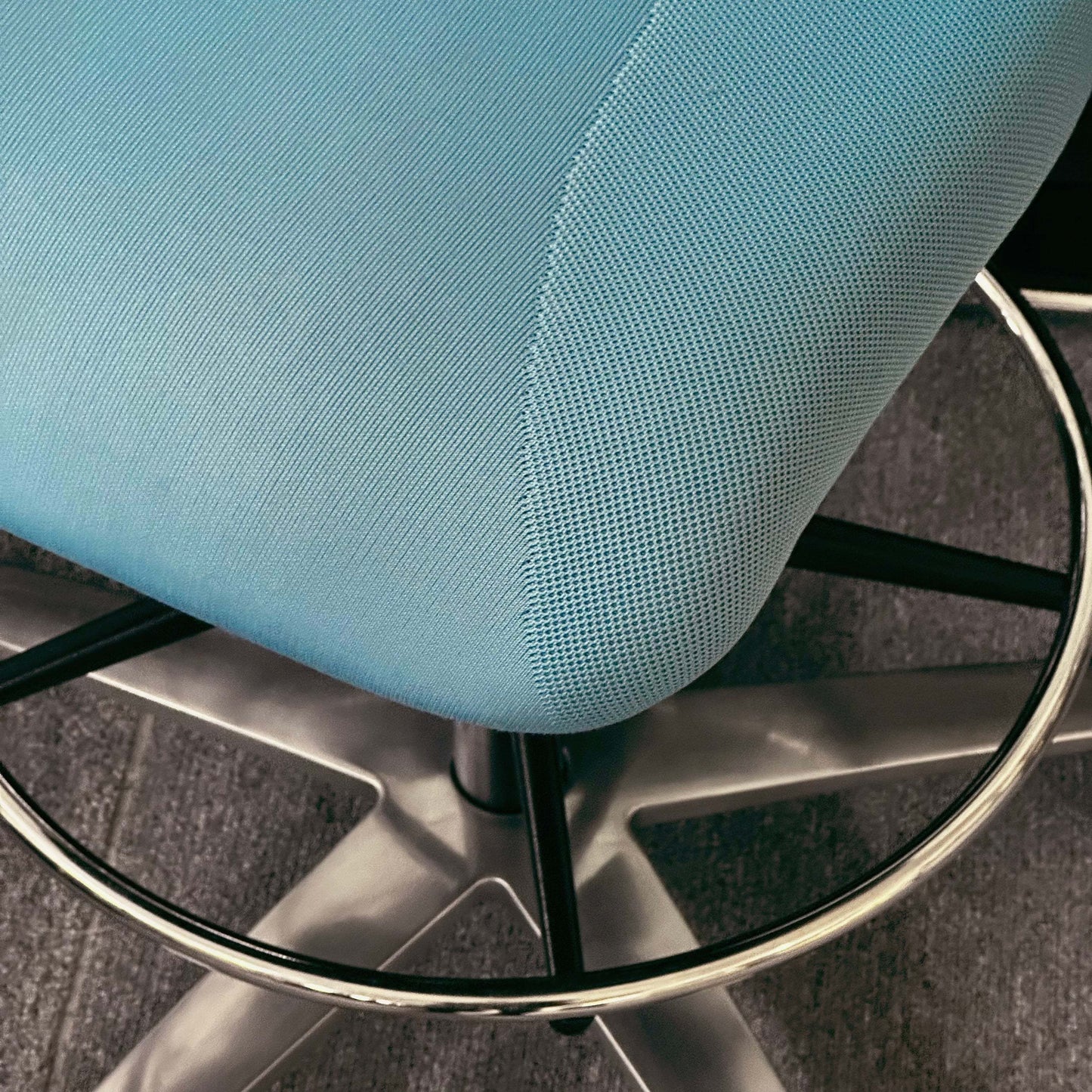 Close-up of blue Wilkhahn In 284/1 Counterstuhl ergonomic swivel counter chair with metal footrest ring and base