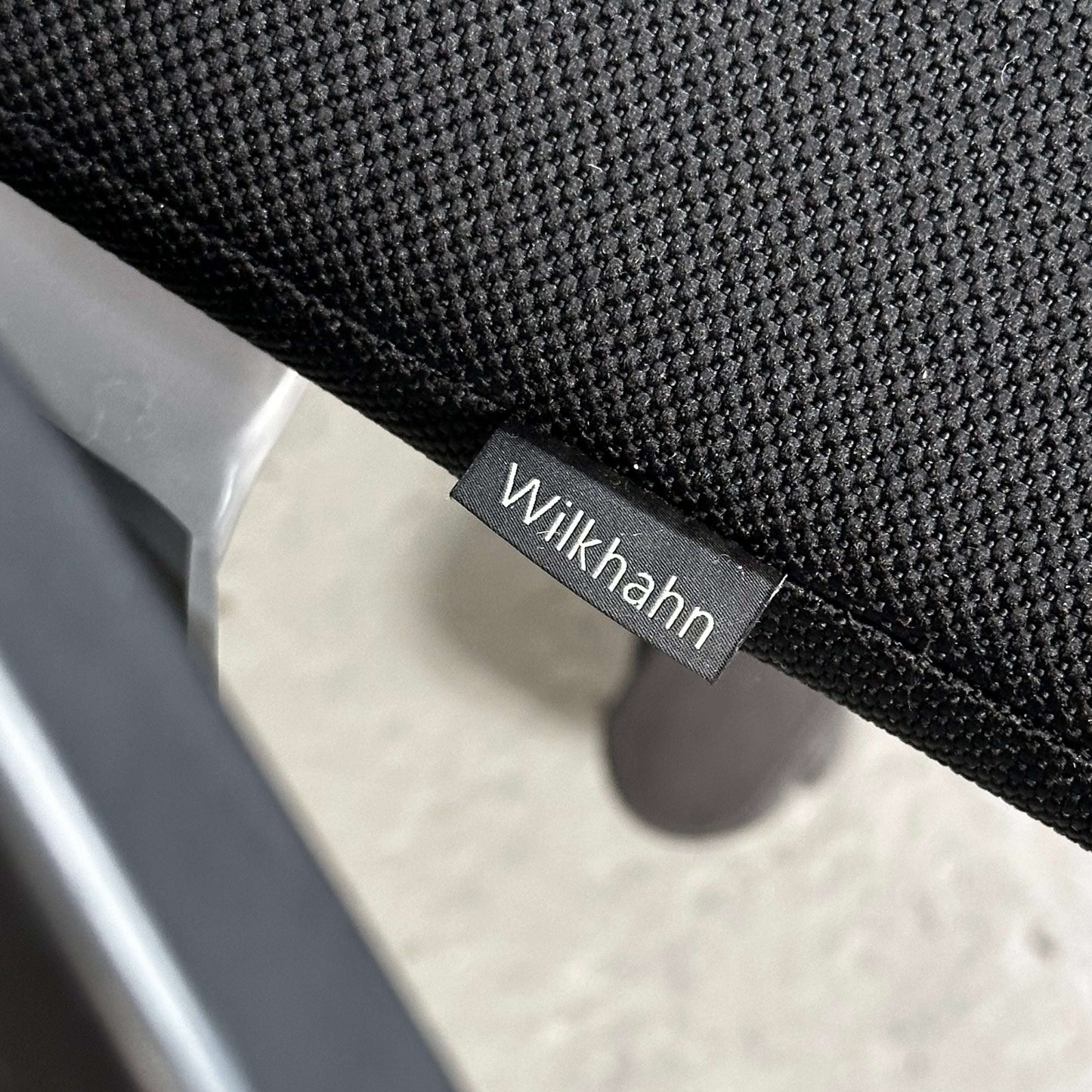 Close-up of Wilkhahn ON office chair with black mesh fabric and visible brand tag