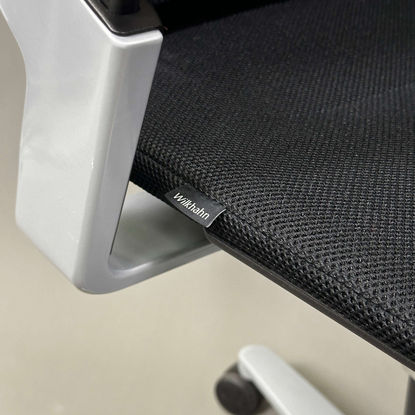 Close-up of Wilkhahn ON office chair seat with black fabric and silver armrest detail