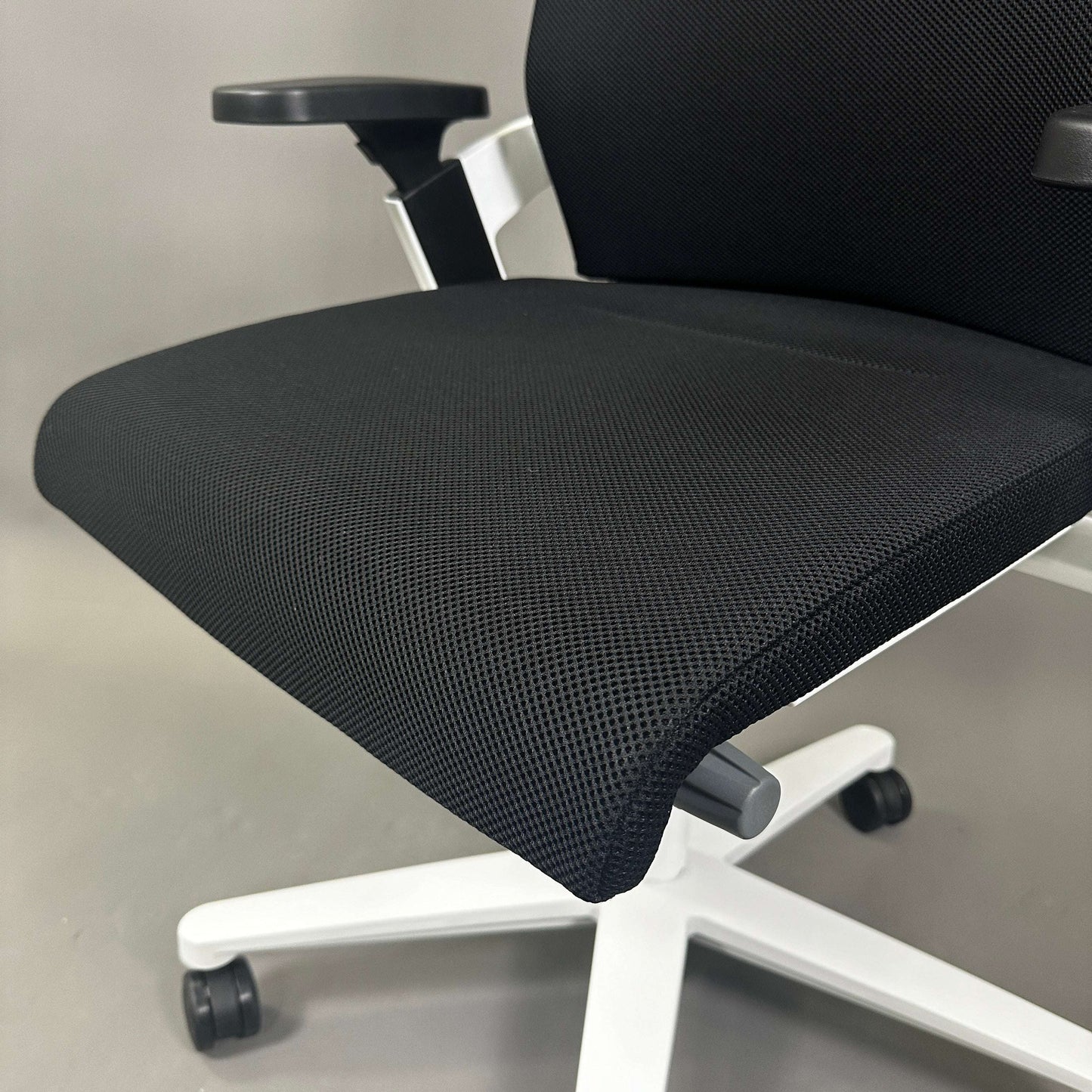 Wilkhahn ON ergonomic office chair with black Fiberflex mesh seat, white plastic base, adjustable armrests and universal casters