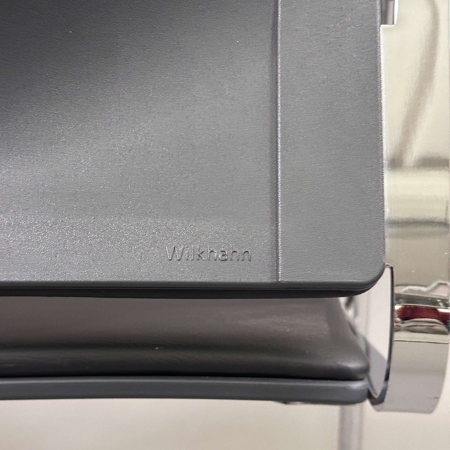 Close-up of Wilkhahn Sito black leather chair seat with chrome frame detailing