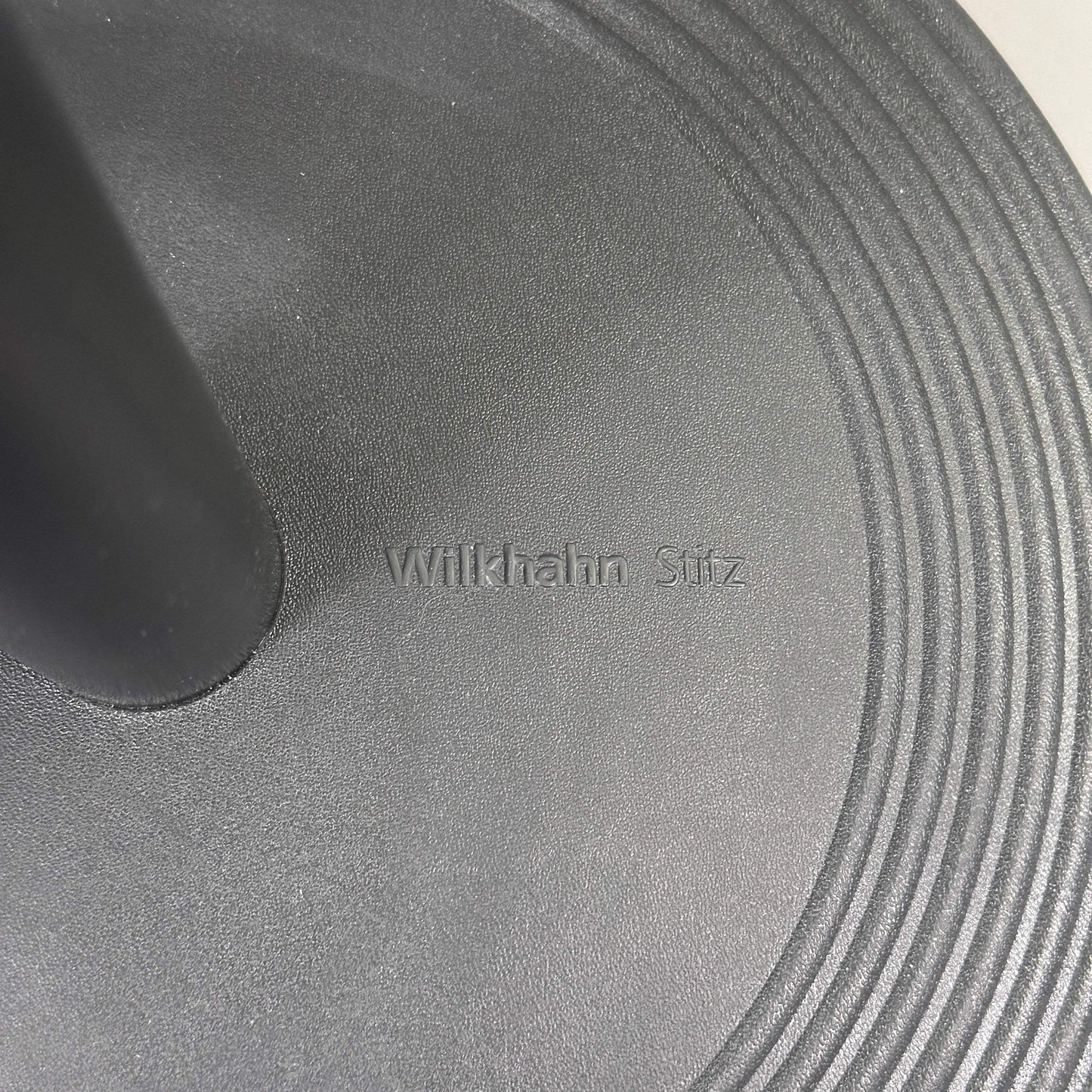 Close-up of Wilkhahn Stehhilfe Stitz standing aid base in black with embossed logo
