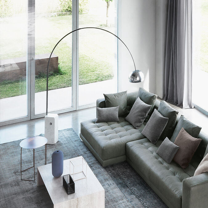 Arco LED Bogenleuchte mit Carraramarmor-Sockel und silbernem Aluminium-Bogen in modernem Wohnzimmer.