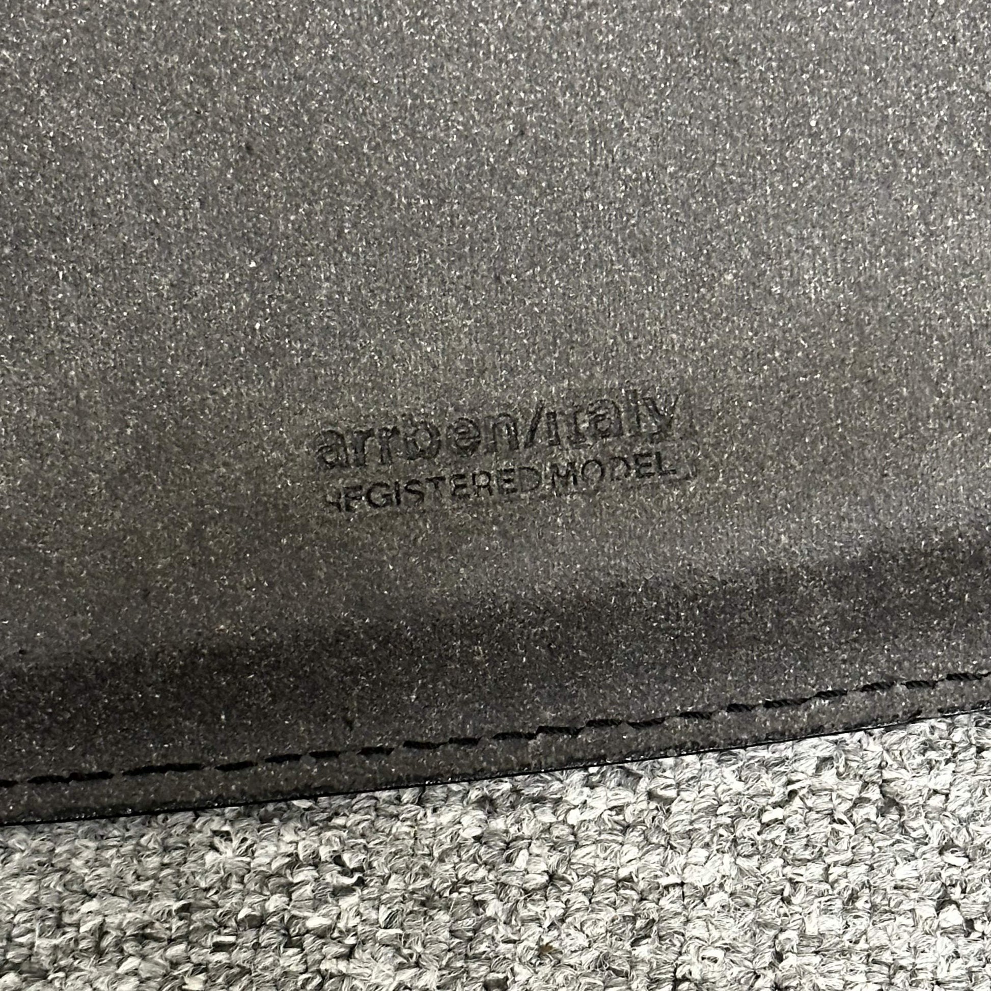 Close-up of Arrben Italy Linda black leather chair with logo embossed on leather seat.