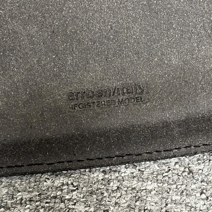 Close-up of Arrben Italy Linda black leather chair with logo embossed on leather seat.