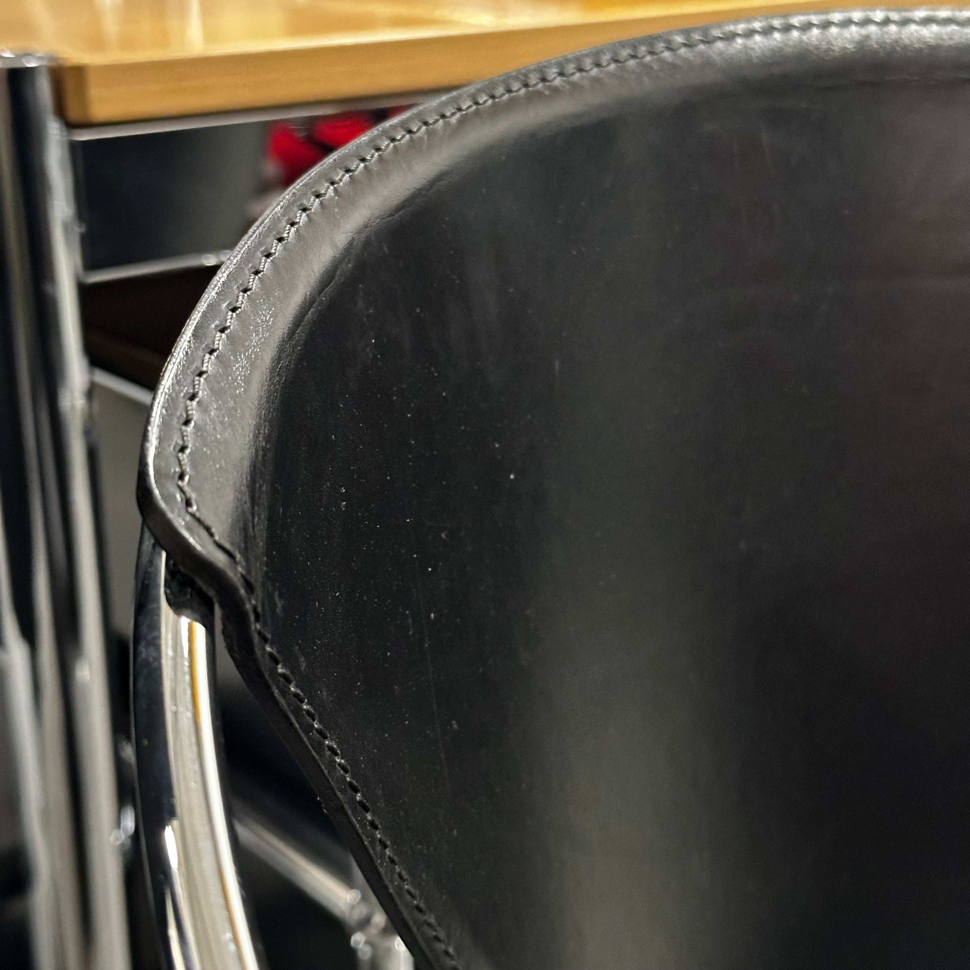 Close-up of black leather seat and chrome steel frame of Arrben Italy Linda chair showcasing fine stitching and craftsmanship