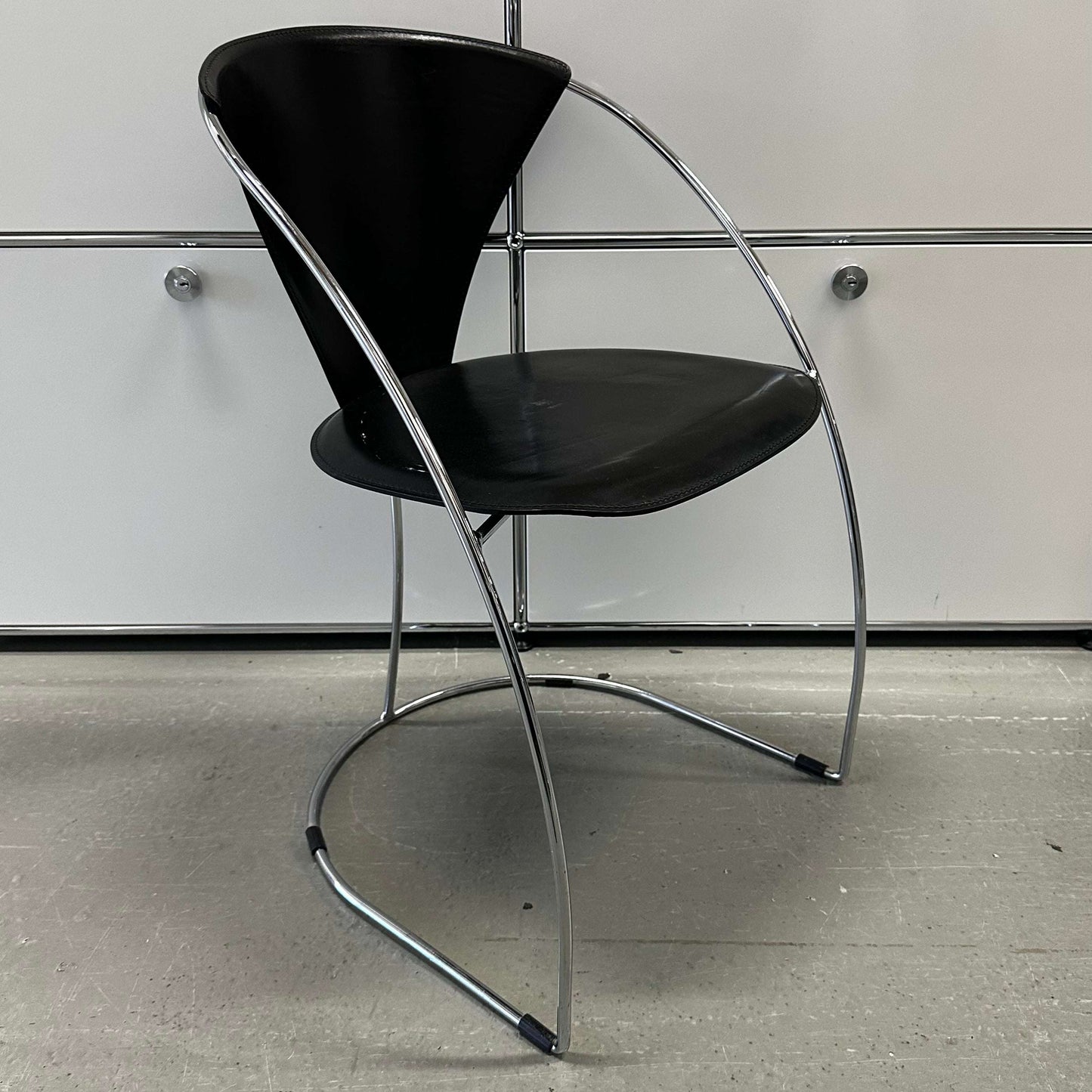 Black leather and chrome chair with steel frame featuring modern curved design, Arrben Italy Linda model