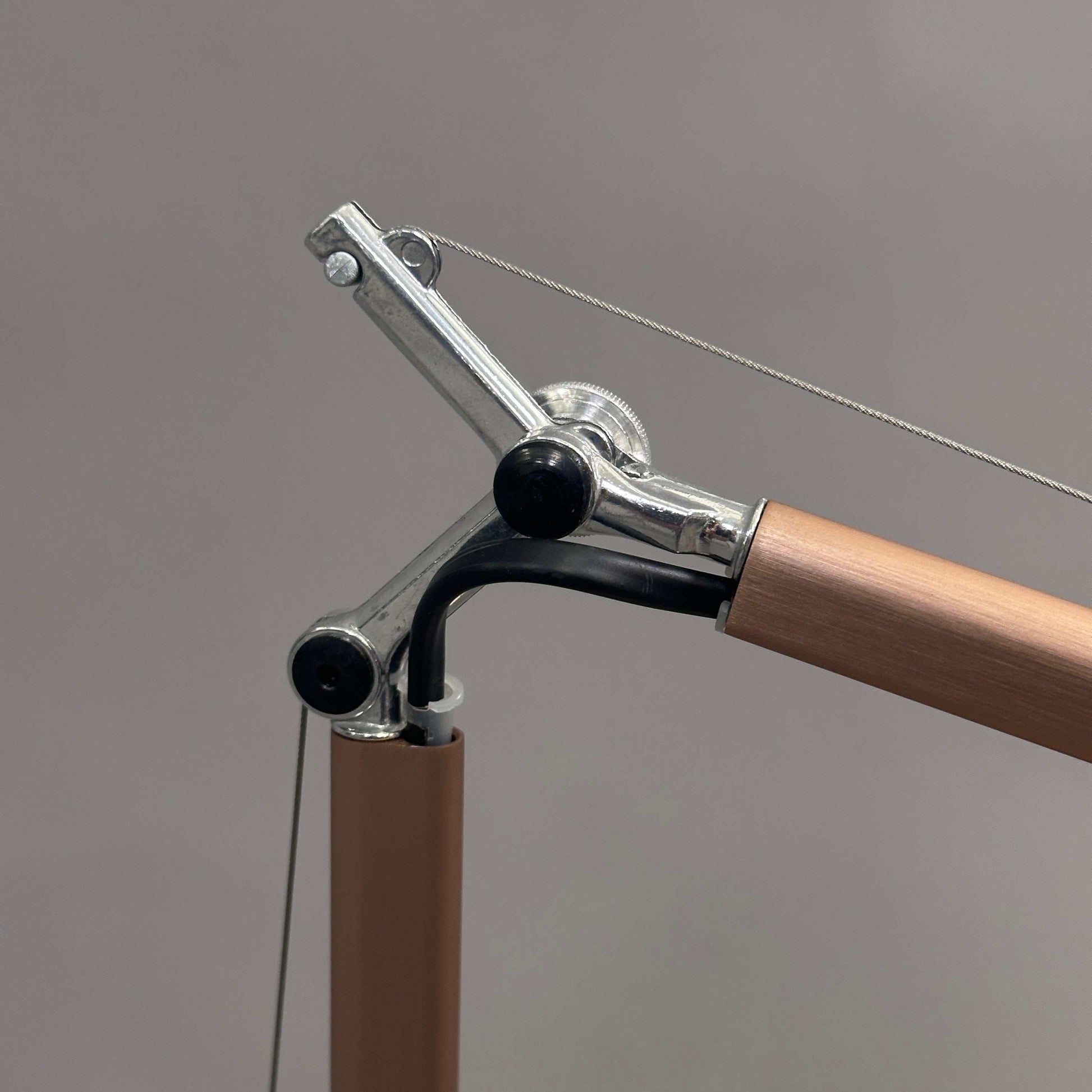 Close-up of Artemide Tolomeo Micro desk lamp in copper with adjustable arm and metal joints