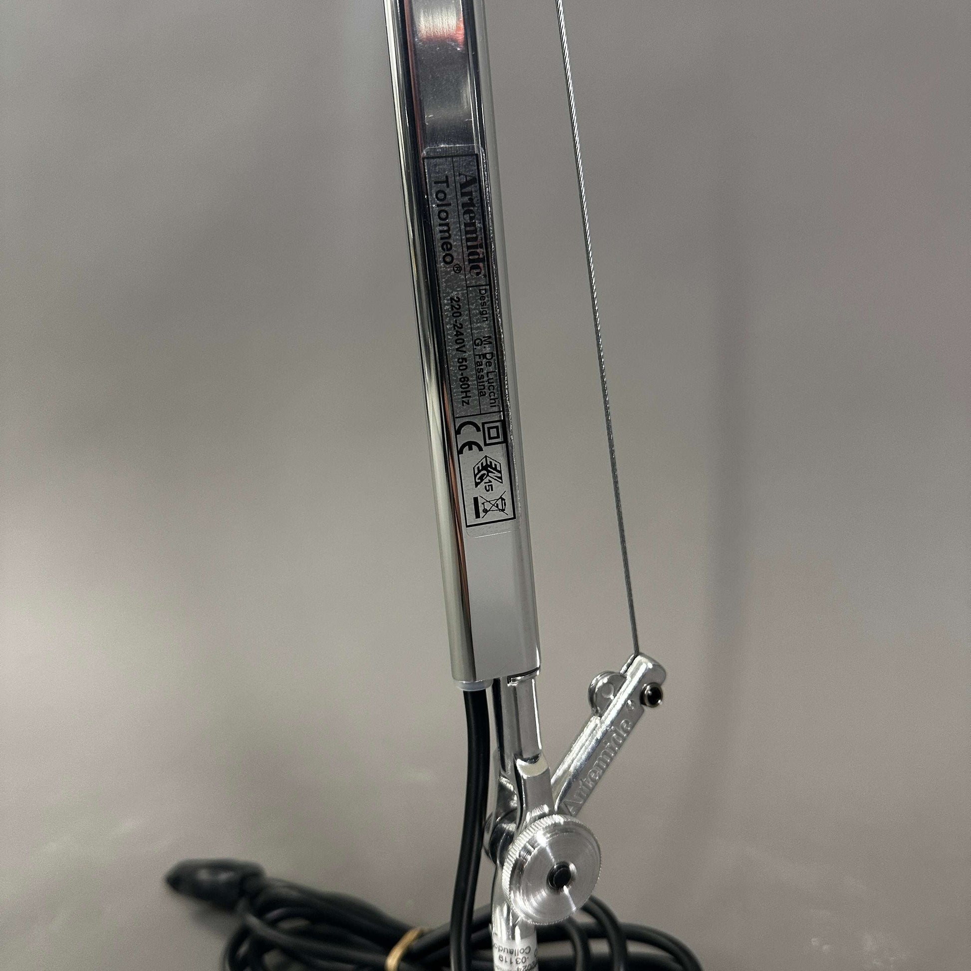Close-up of polished aluminum Artemide Tolomeo Tavolo adjustable arm with cable and joint details