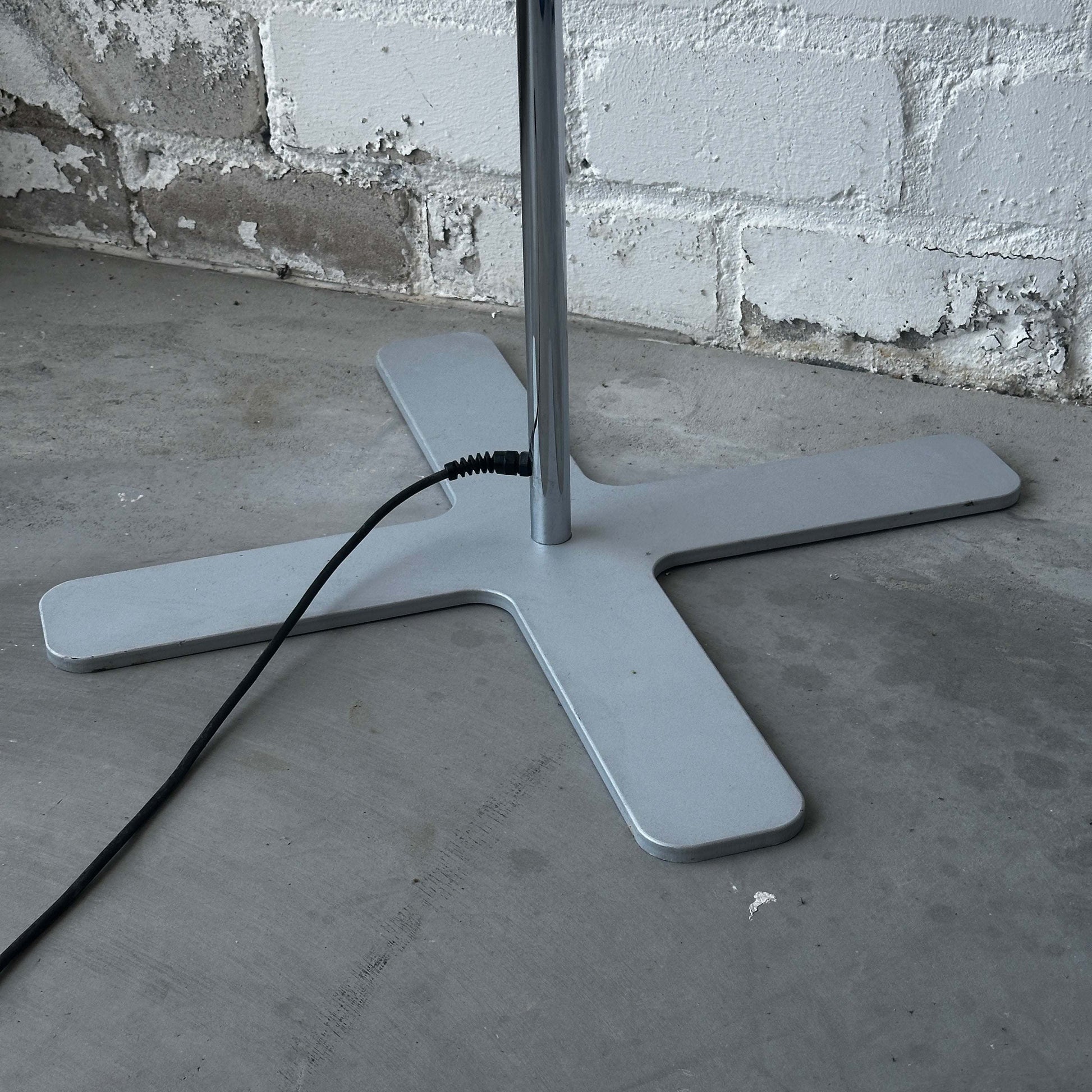 Belux Koi Stehlampe chromer Standfuß mit Stromkabel vor weißer Backsteinwand