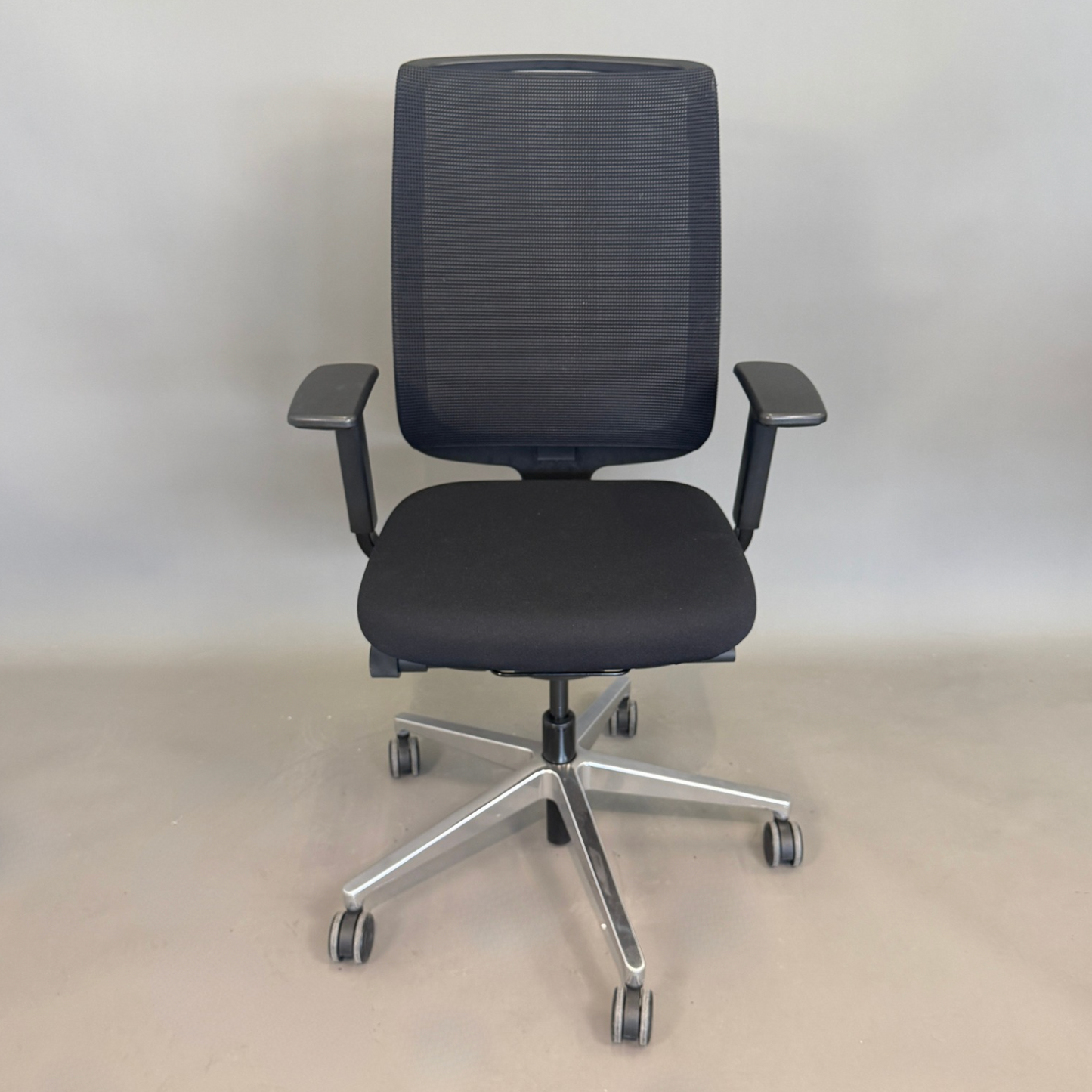 Steelcase Reply Bürostuhl schwarz mit Mesh-Rückenlehne und Chrom-Fußkreuz, höhenverstellbar und ergonomisch.