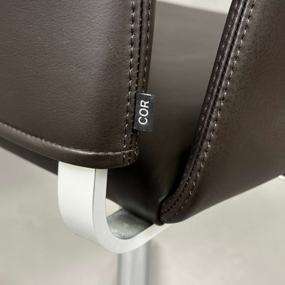 Nahaufnahme des COR Fino Drehstuhls mit dunkelbraunem Leder und poliertem Aluminiumgestell