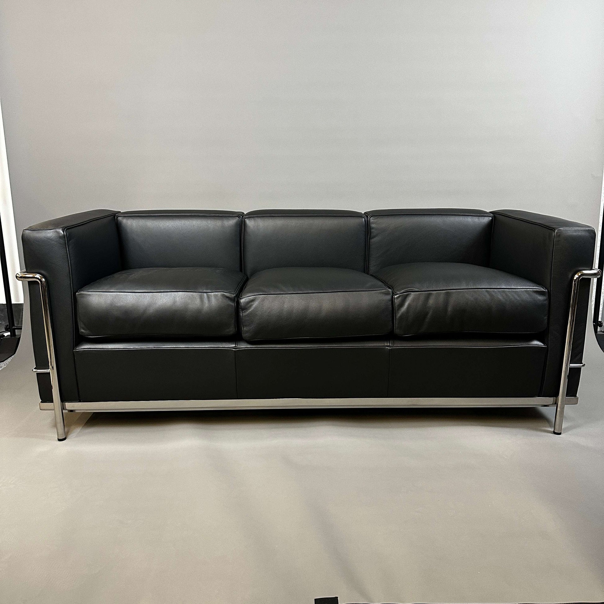 Black Cassina LC2 three-seater leather sofa with chrome steel frame, modern design