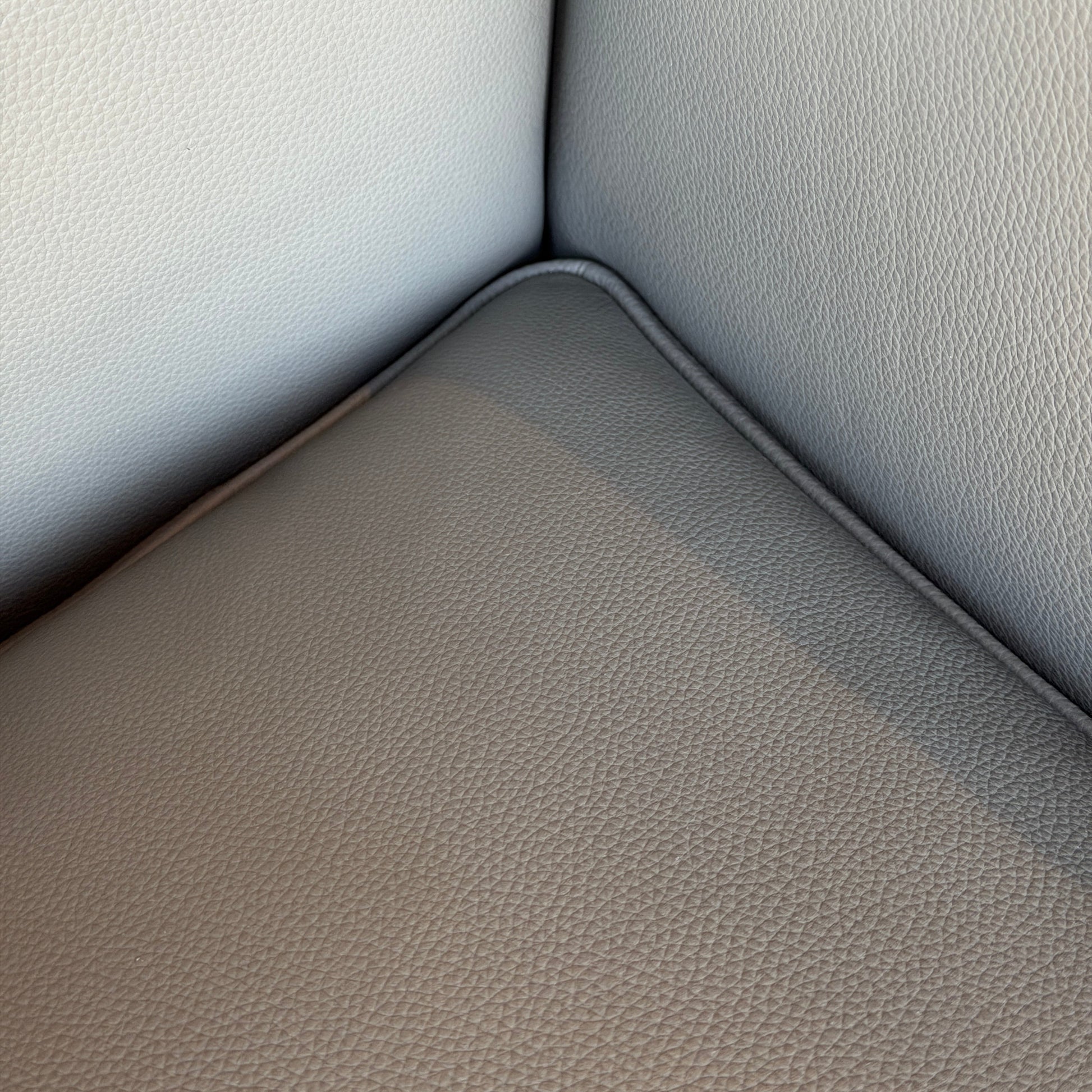 Nahaufnahme des Cassina LC2 Ledersessels in grau mit schottischem Leder und verchromtem Stahlrohrgestell.