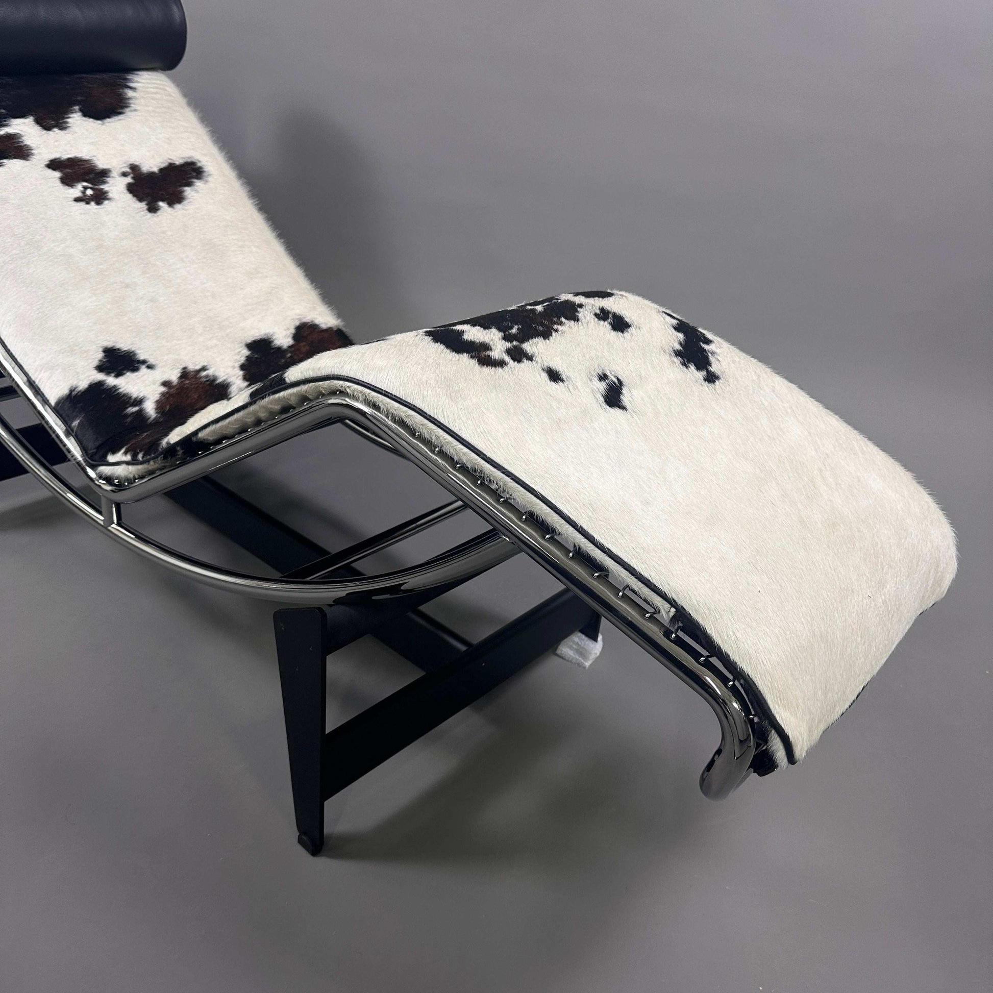 Cassina LC4 Chaiselongue Liege mit ergonomischem Design und geflecktem Kuhfellbezug schwarz-weiß