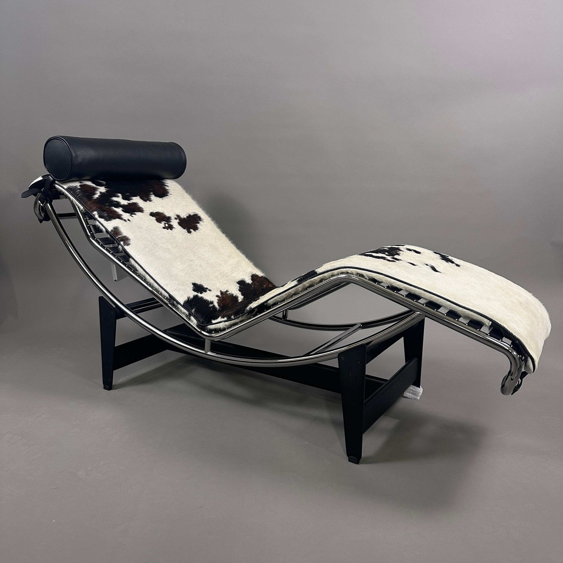 Cassina LC4 Chaiselongue Liege mit schwarzem und weißem Kuhfell, verstellbar, schwarzer Leder-Nackenrolle, moderner Designklassiker