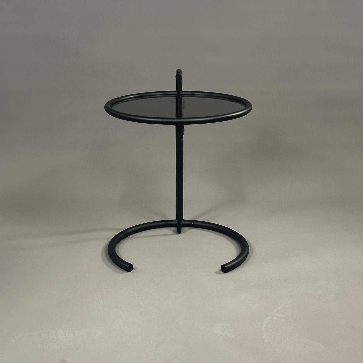 ClassiCon Eileen Gray Beistelltisch schwarz matt mit runder dunkler Glasplatte und höhenverstellbarem Stahlrohrgestell