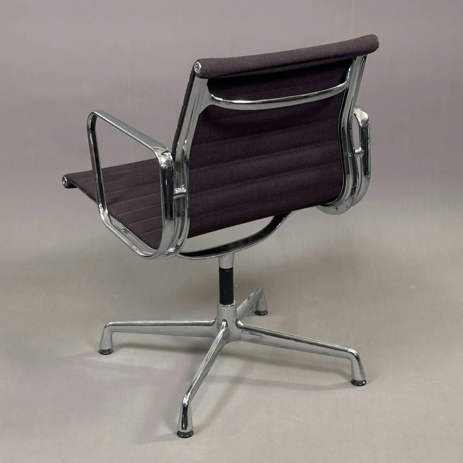Vitra EA 108 Bürostuhl mit schwarzem Hopsak-Bezug und chromfarbenem Drehgestell, Rückansicht.