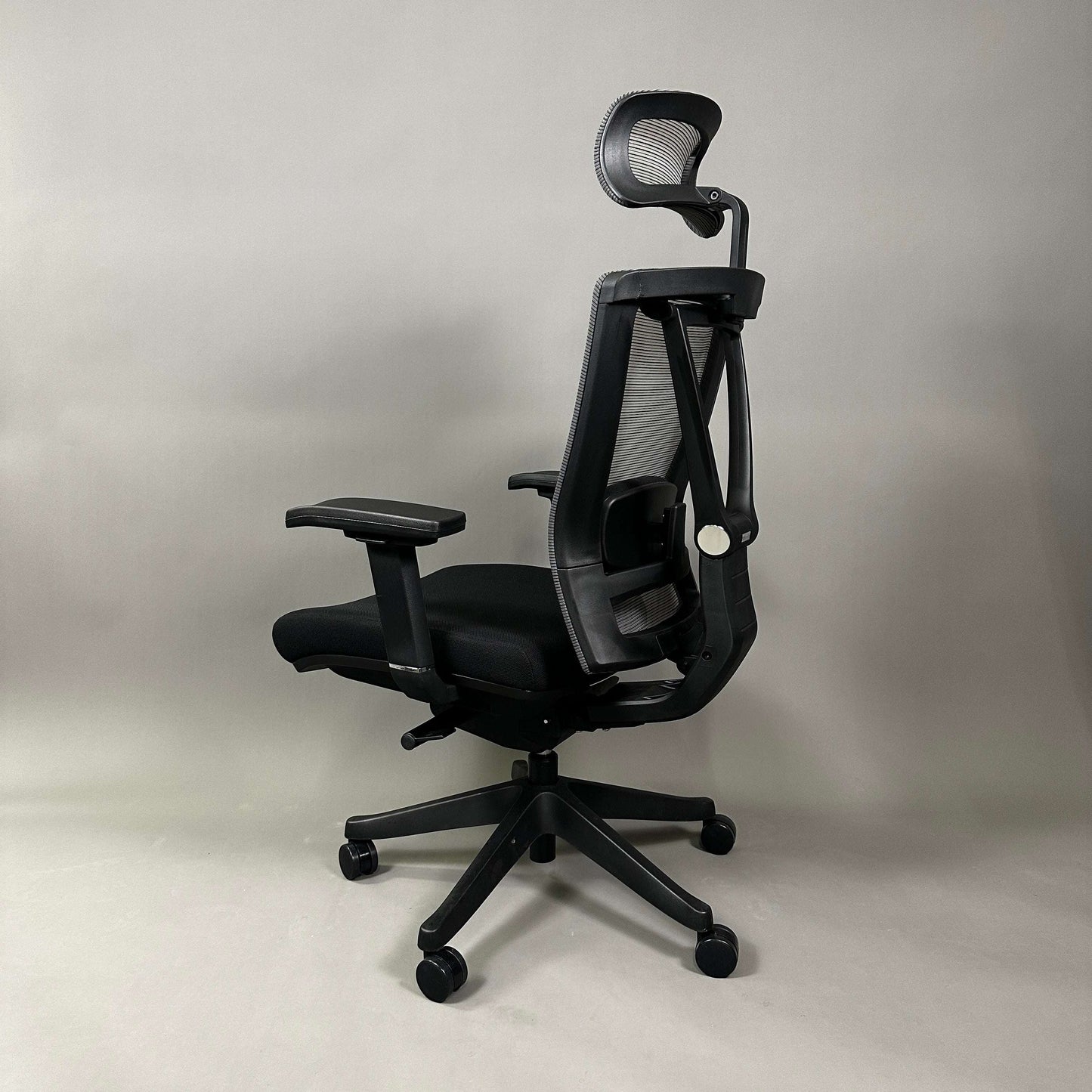 Ergonomic black office chair Ergo1 schwarz with mesh backrest, adjustable headrest, 4D armrests, and black fabric seat