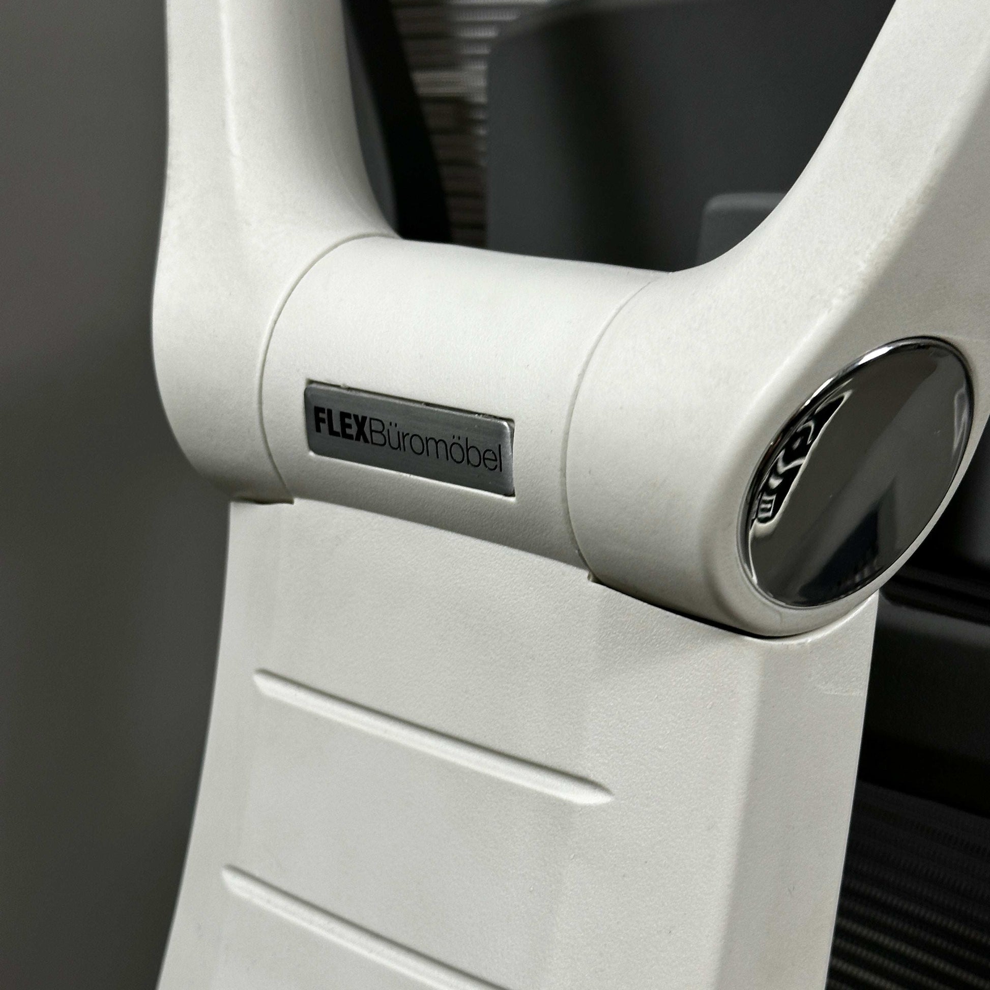 Close-up of white aluminum frame of ergonomic office chair with FLEX Büromöbel logo