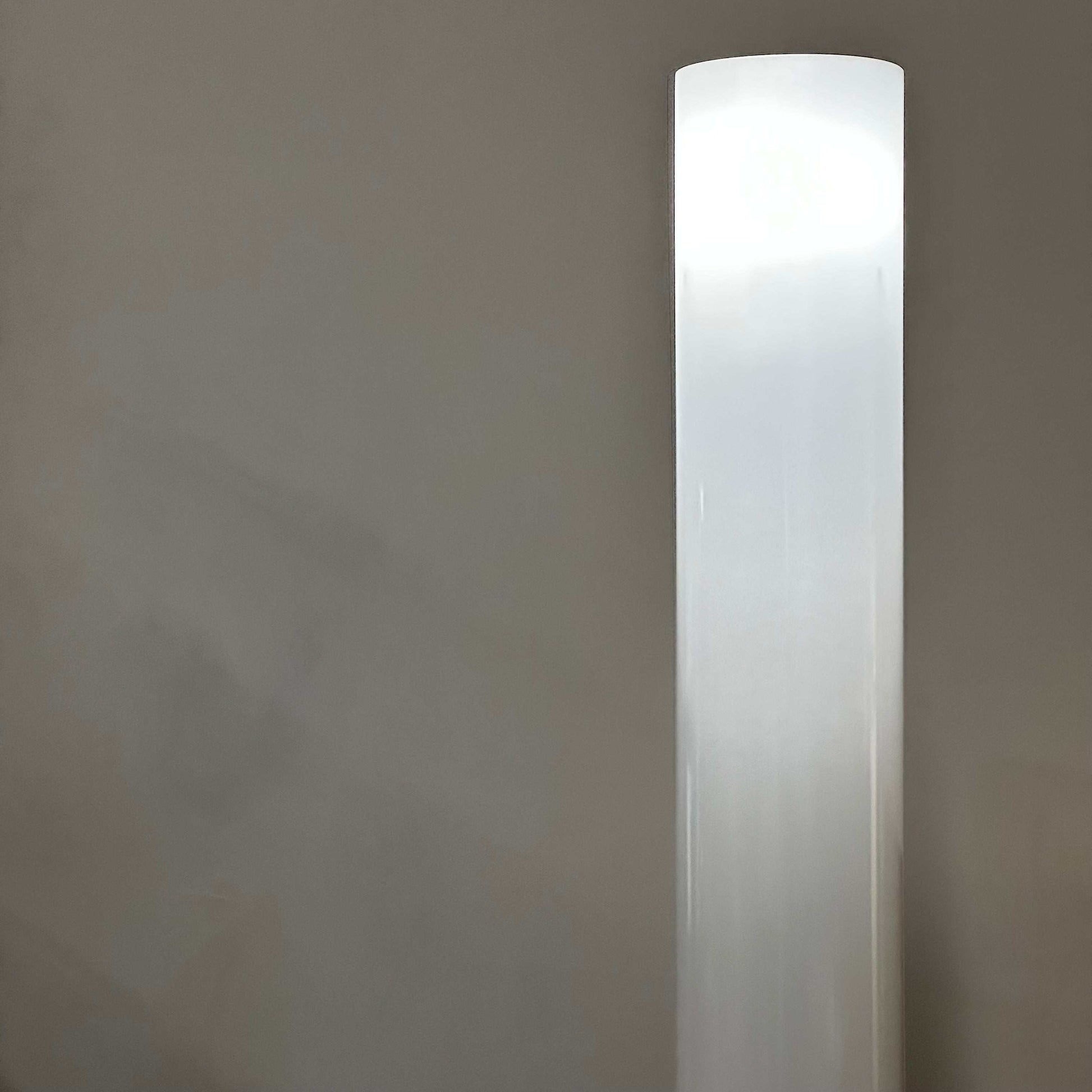 Tall white modern FLOS Stylos Stehlampe floor lamp with sleek minimalist design and diffuse light on a gray background