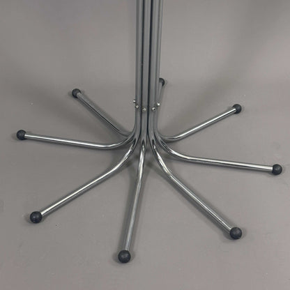 Fritz Hansen Coat Tree silver metal base with multiple arms and black rubber tips on gray background