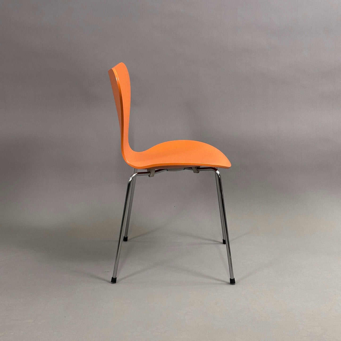 Fritz Hansen Serie 7 Stapelstuhl mit orange lasierter Holzsitzschale und chromfarbenem Untergestell