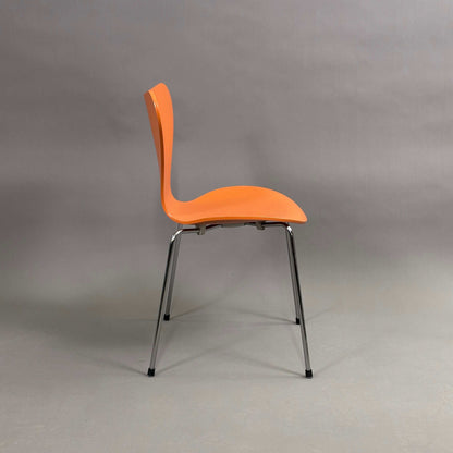 Fritz Hansen Serie 7 Stapelstuhl mit orange lasierter Holzsitzschale und chromfarbenem Untergestell