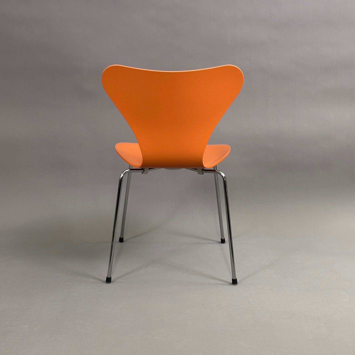 Fritz Hansen Serie 7 Stapelstuhl mit orange lasierter Holzsitzschale und chromfarbenem Untergestell, 525 Chavalier Orange