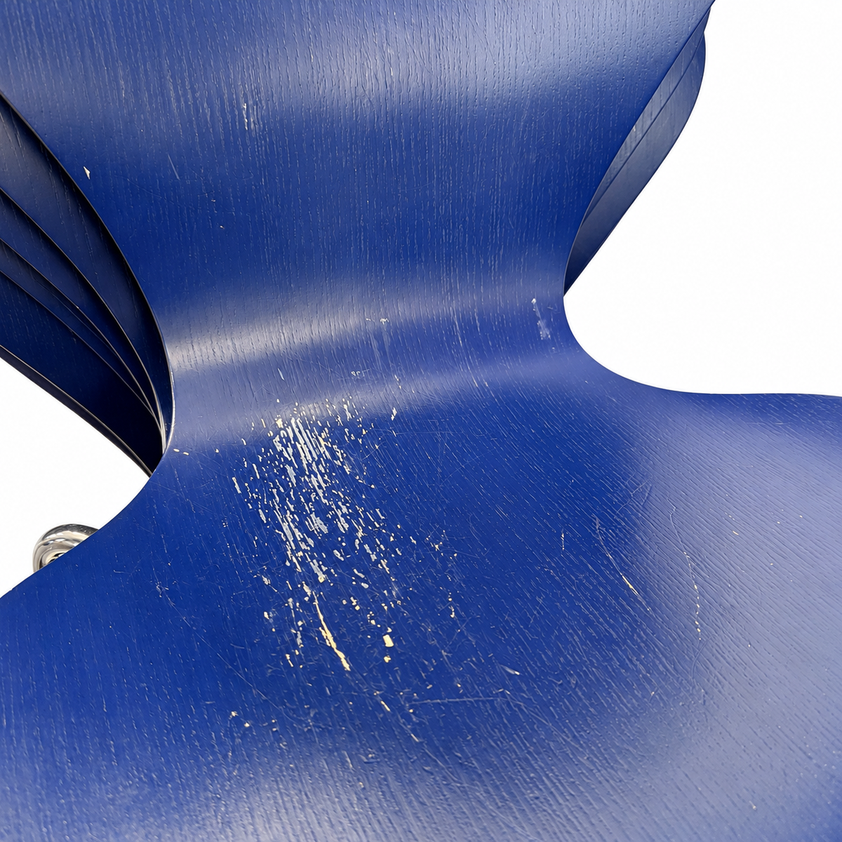 Blauer Fritz Hansen Serie 7 Stapelstuhl aus Holz mit sichtbaren Gebrauchsspuren auf der Sitzfläche.