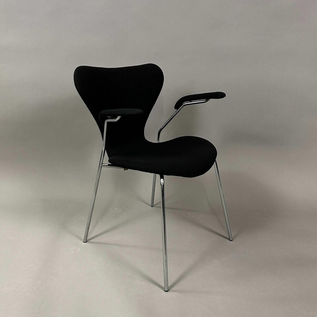 Fritz Hansen Serie 7 Stuhl | Gepolstert mit Armlehnen | Sitzfläche Stoff schwarz | Gestell Stahlrohr verchromt | Gebrauchte Büromöbel