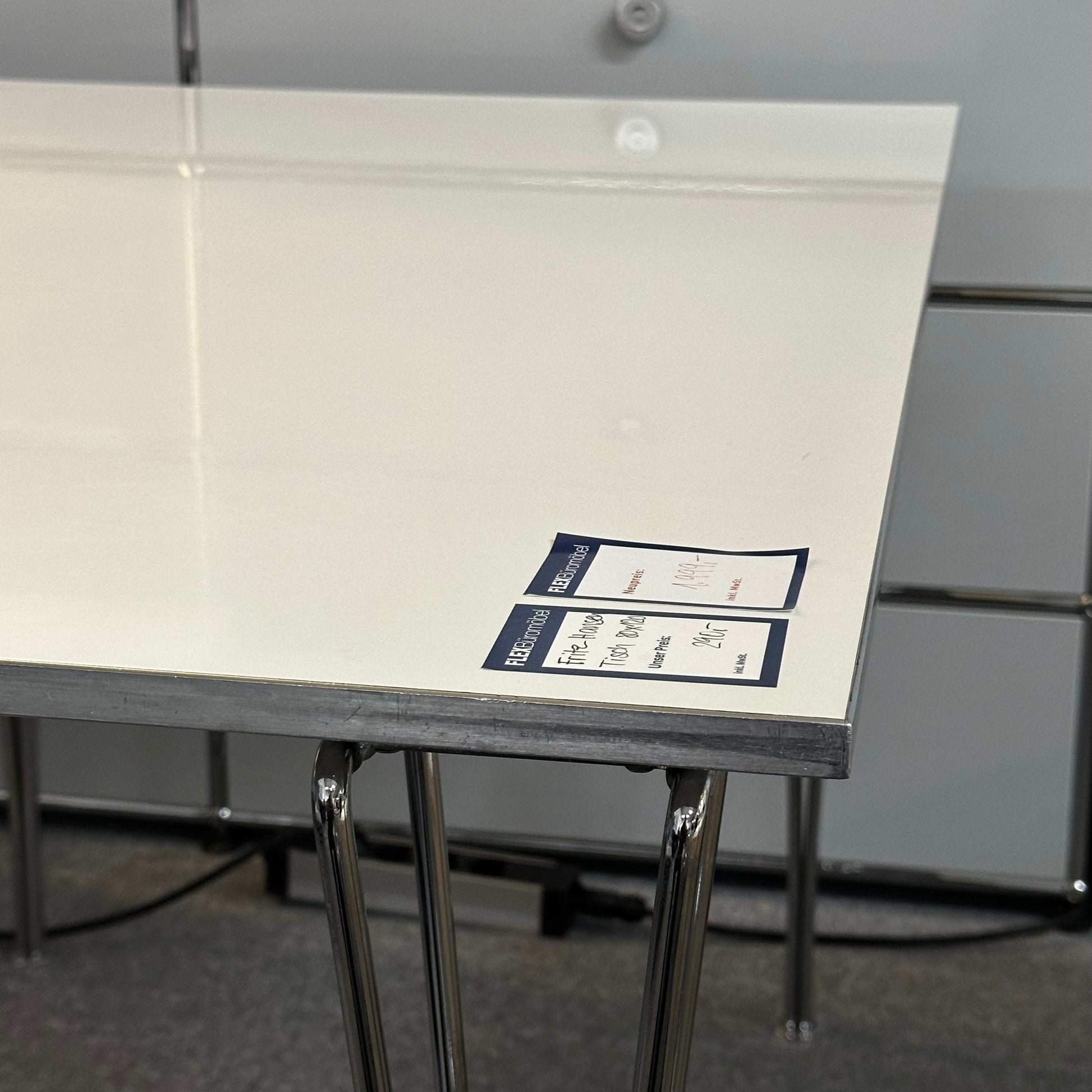 Fritz Hansen Tisch 80x120cm with sleek white tabletop and chrome legs, modern and elegant design for dining or office use.