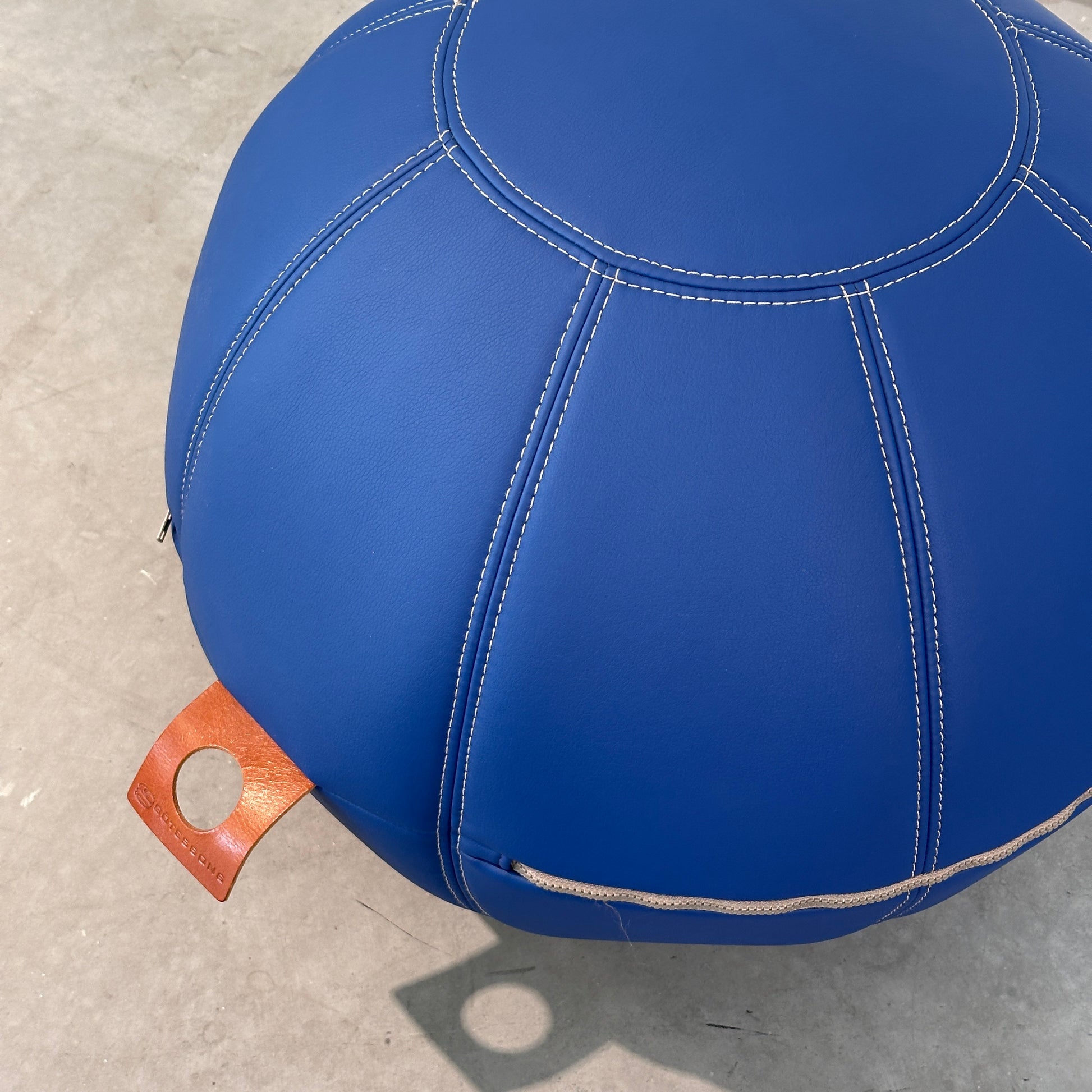 Götesons Office Ballz Sitzball aus blauem Kunstleder mit beigen Nähten und brauner Trageschlaufe.
