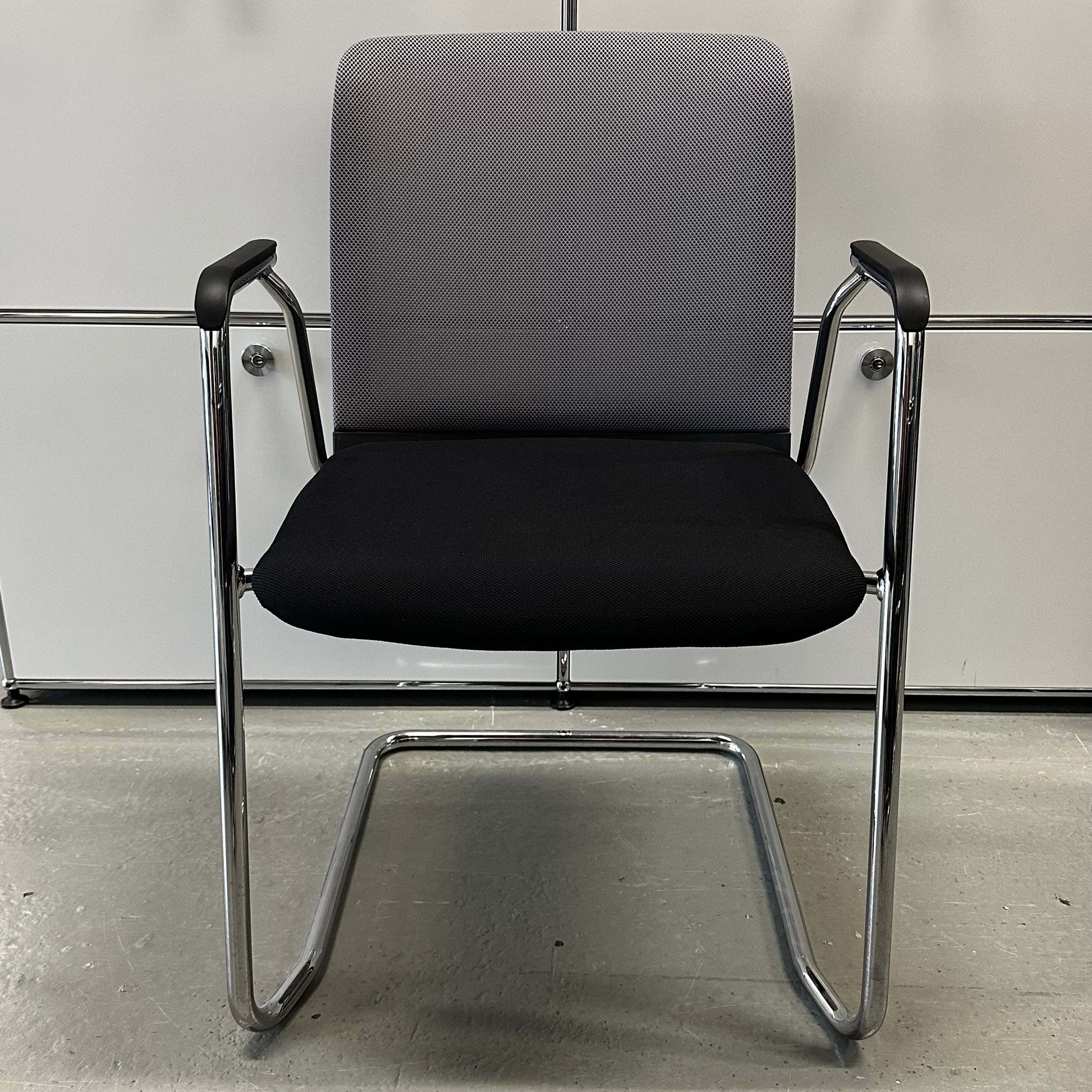 Haworth Comforto 29 visitor chair with ergonomic seat, black cushion, gray mesh backrest, and chrome cantilever frame for office or conference room seating