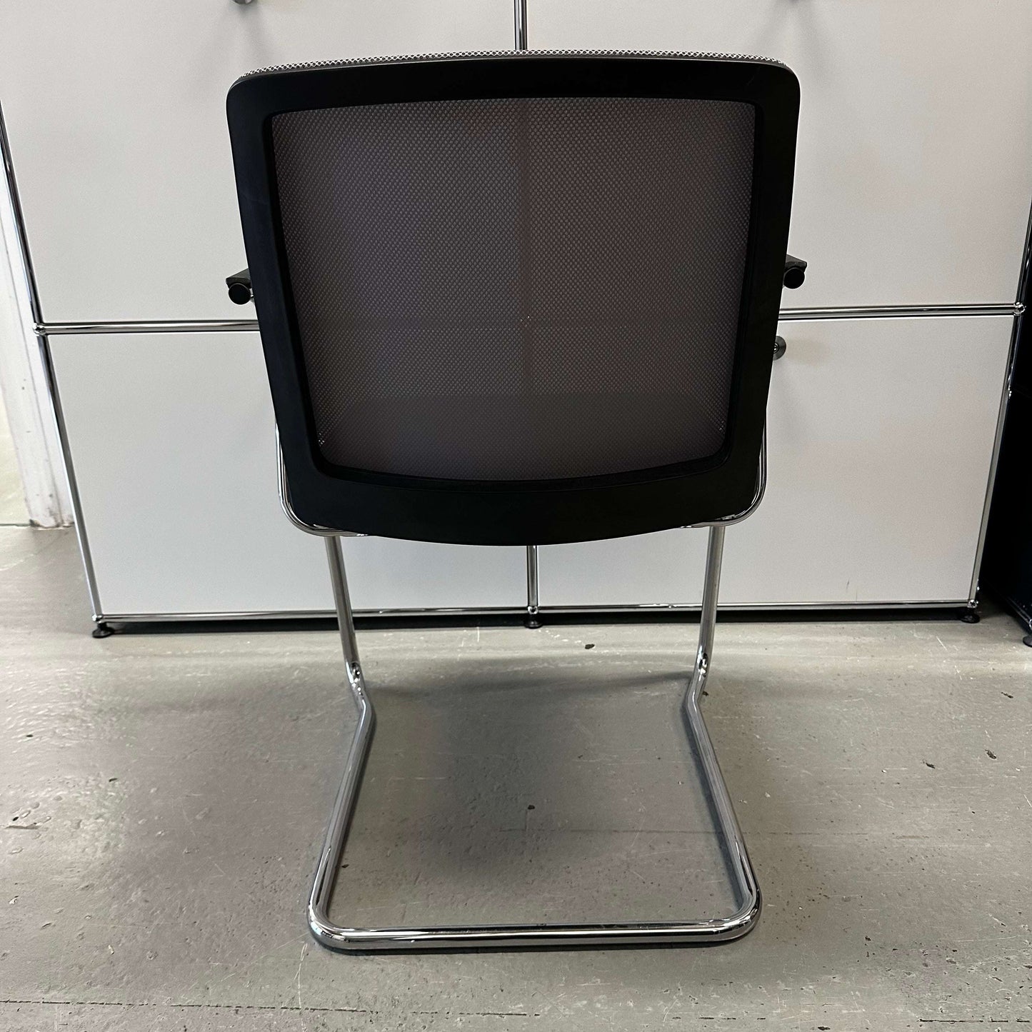 Haworth Comforto 29 visitor chair with ergonomic mesh back and chrome cantilever frame viewed from the back
