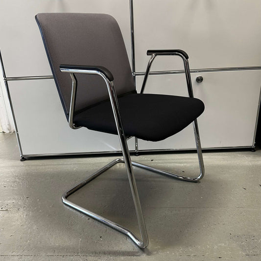 Haworth Comforto 29 visitor chair with ergonomic design, gray backrest, black seat, and chrome cantilever frame.