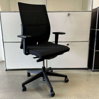 Black Haworth Comforto 39 office chair with mesh backrest, adjustable armrests, seat height, and black base with caster wheels
