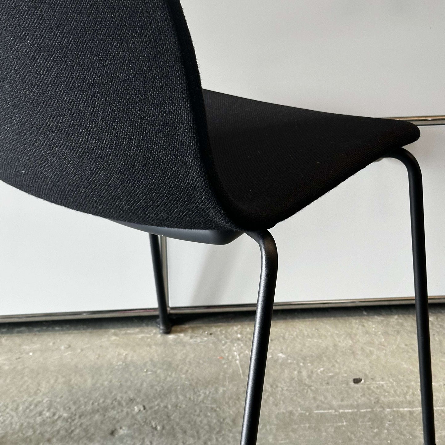 Black Hay Chair AAC 17 with sleek design and metal legs on a concrete floor