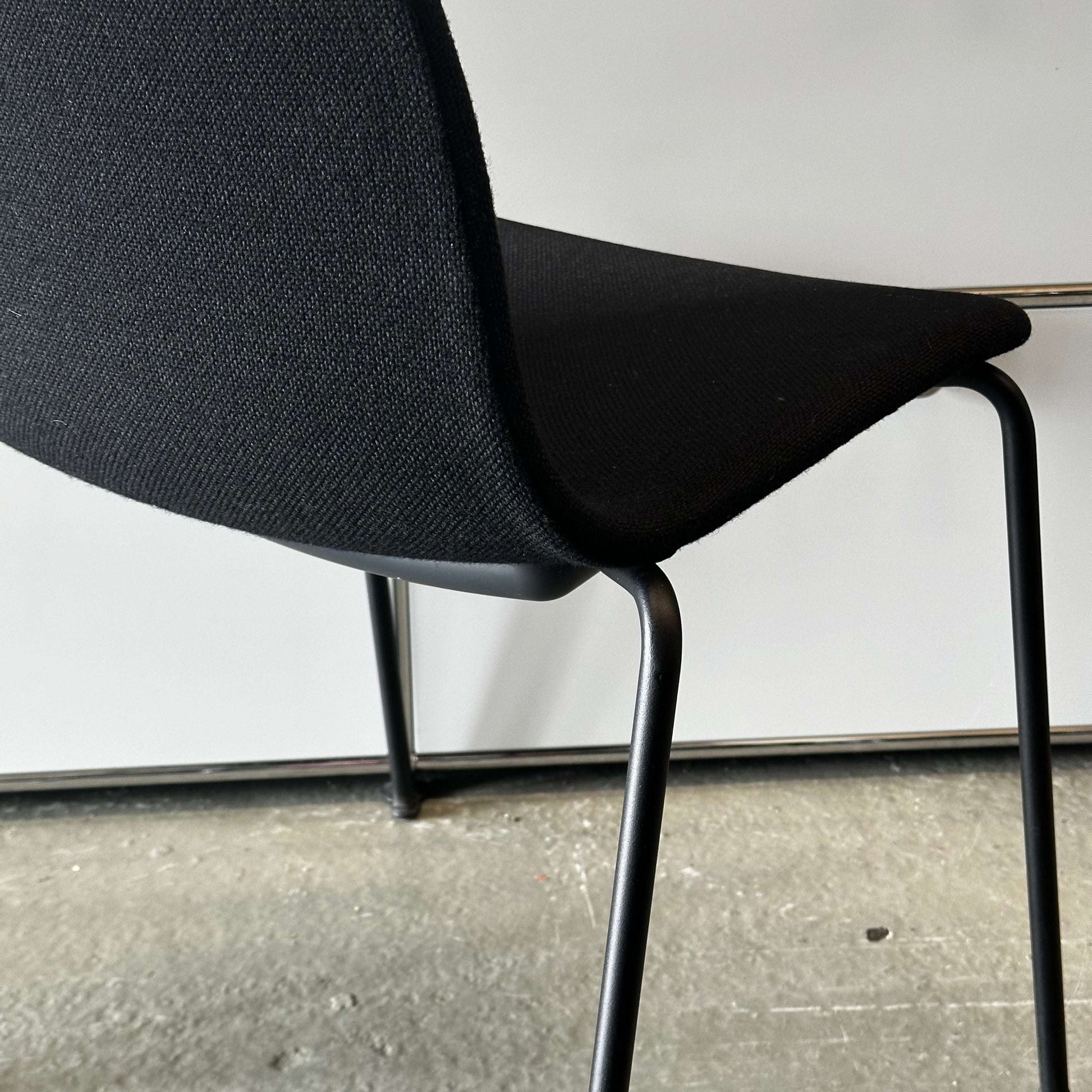 Black Hay Chair AAC 17 with sleek design and metal legs on a concrete floor