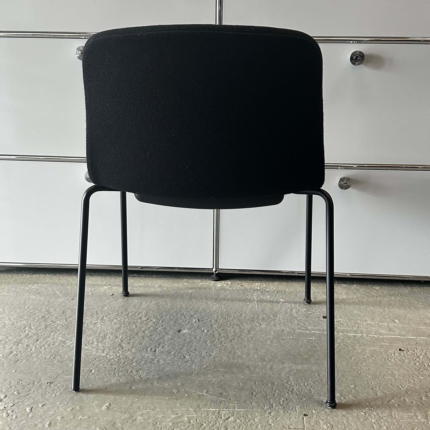 Black Hay Chair AAC 17 with sleek metal legs viewed from the back in a modern interior setting