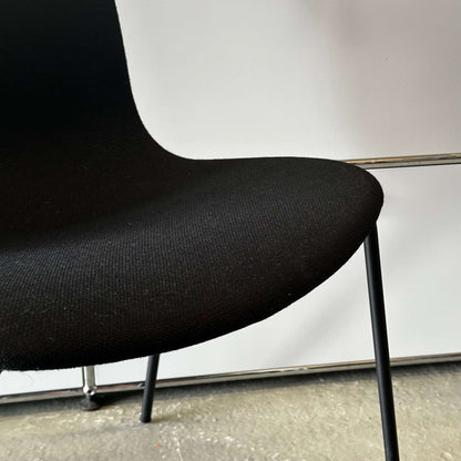 Black modern Hay Chair AAC 17 with sleek fabric seat and slender metal legs on concrete floor