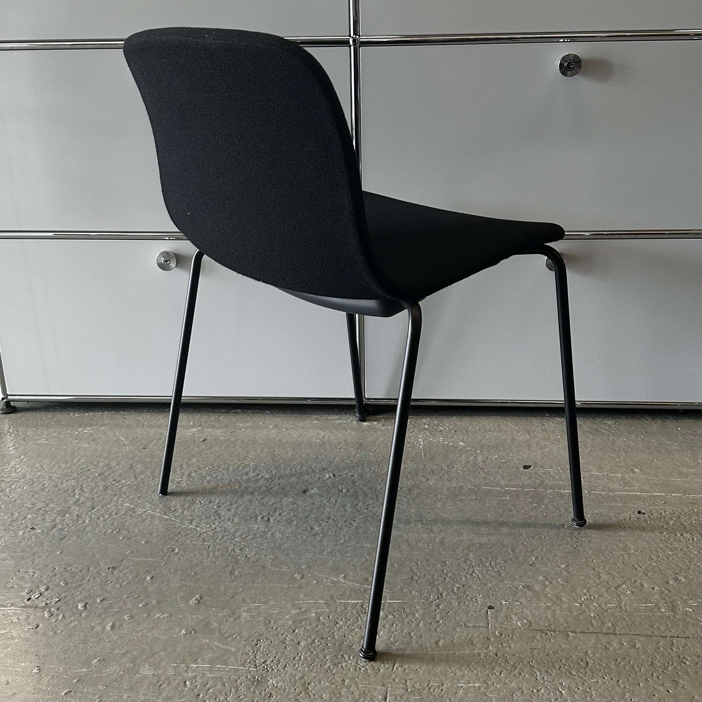 Modern black Hay Chair AAC 17 with sleek design and metal legs against a gray background
