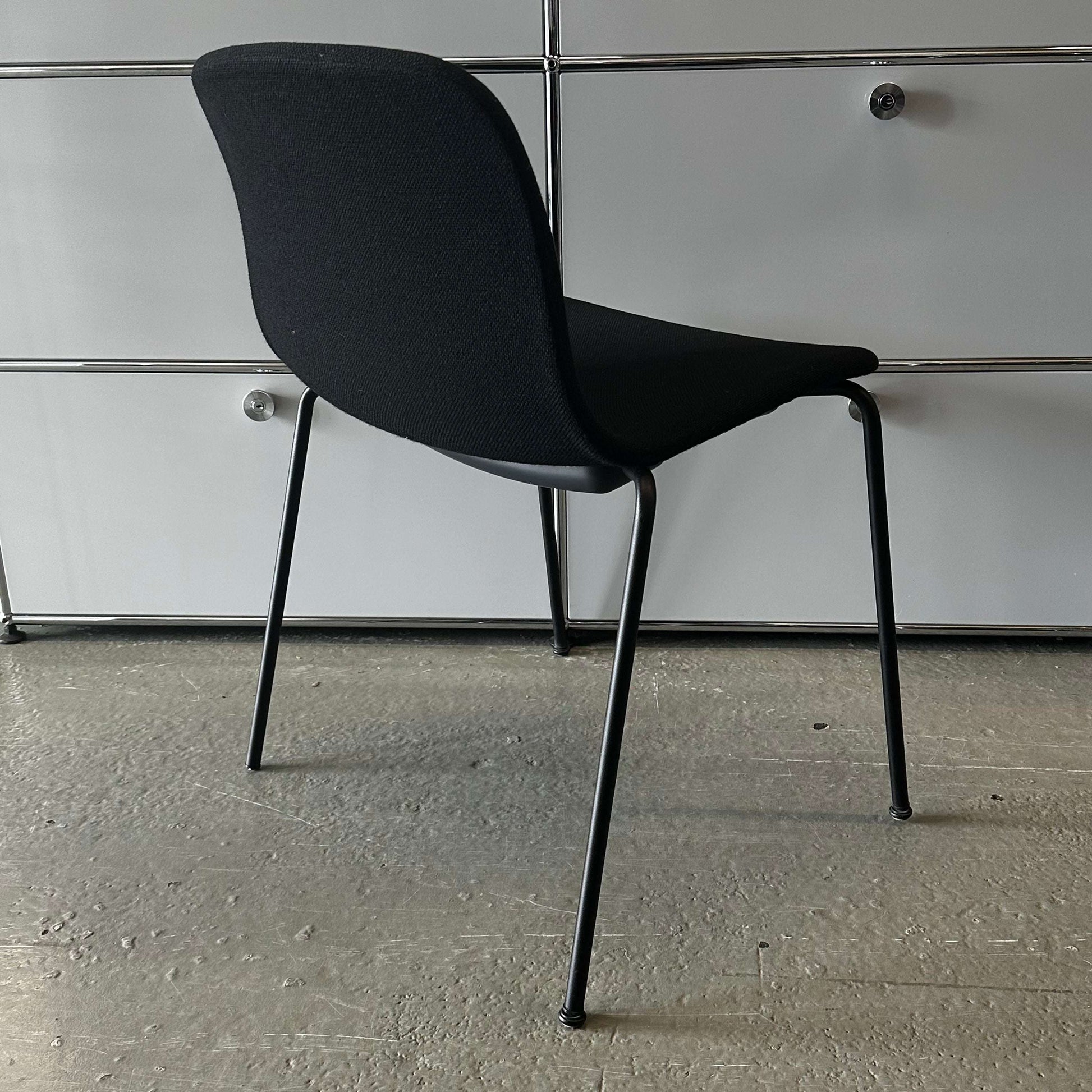 Modern black Hay Chair AAC 17 with sleek design and metal legs against a gray background